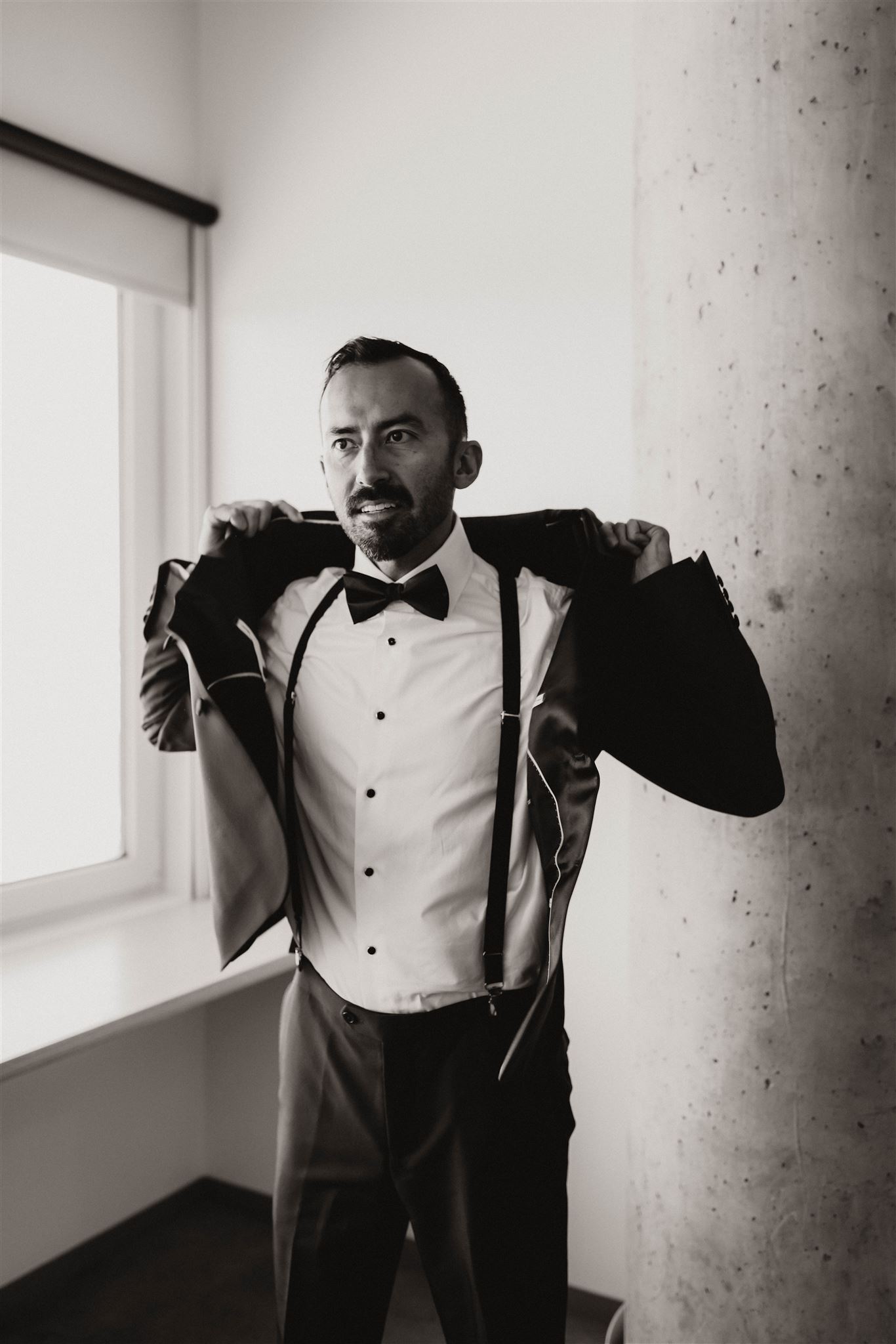 groom putting on suit for fall wedding in colorado 
