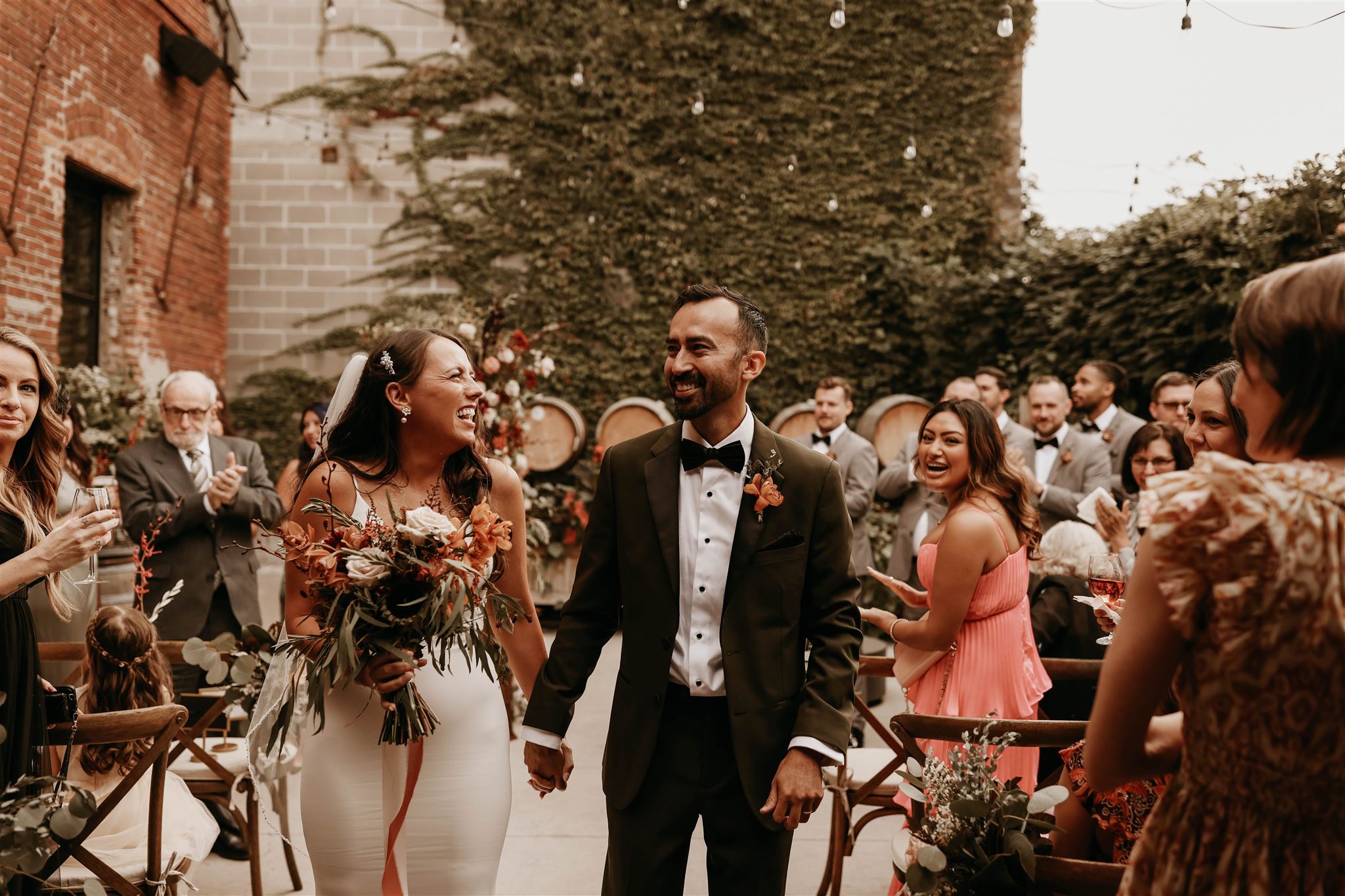 bride and groom smiling and  walking down aisle at fall wedding in colorado 