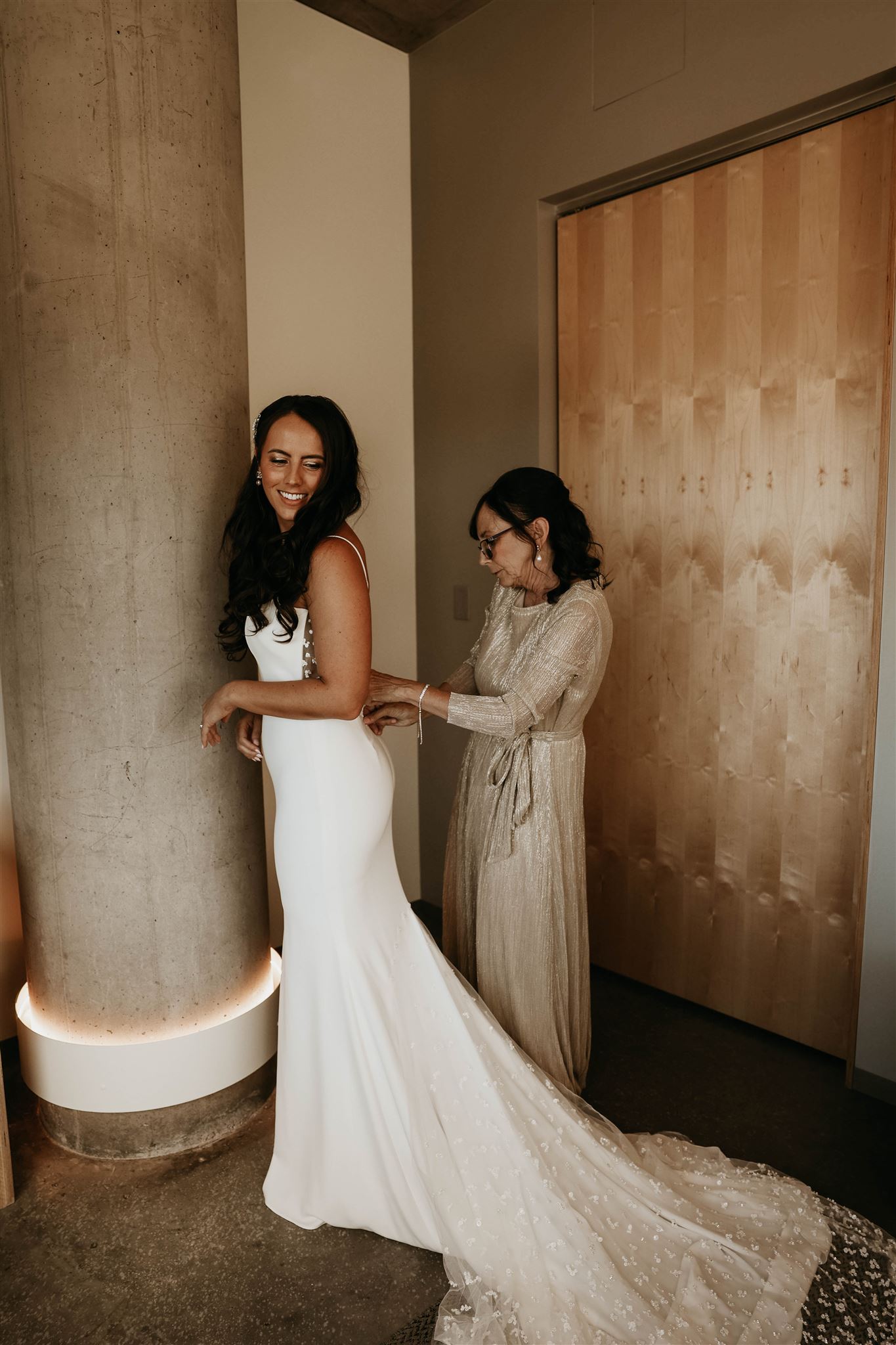 mother helping bride get on dress for fall wedding in colorado 