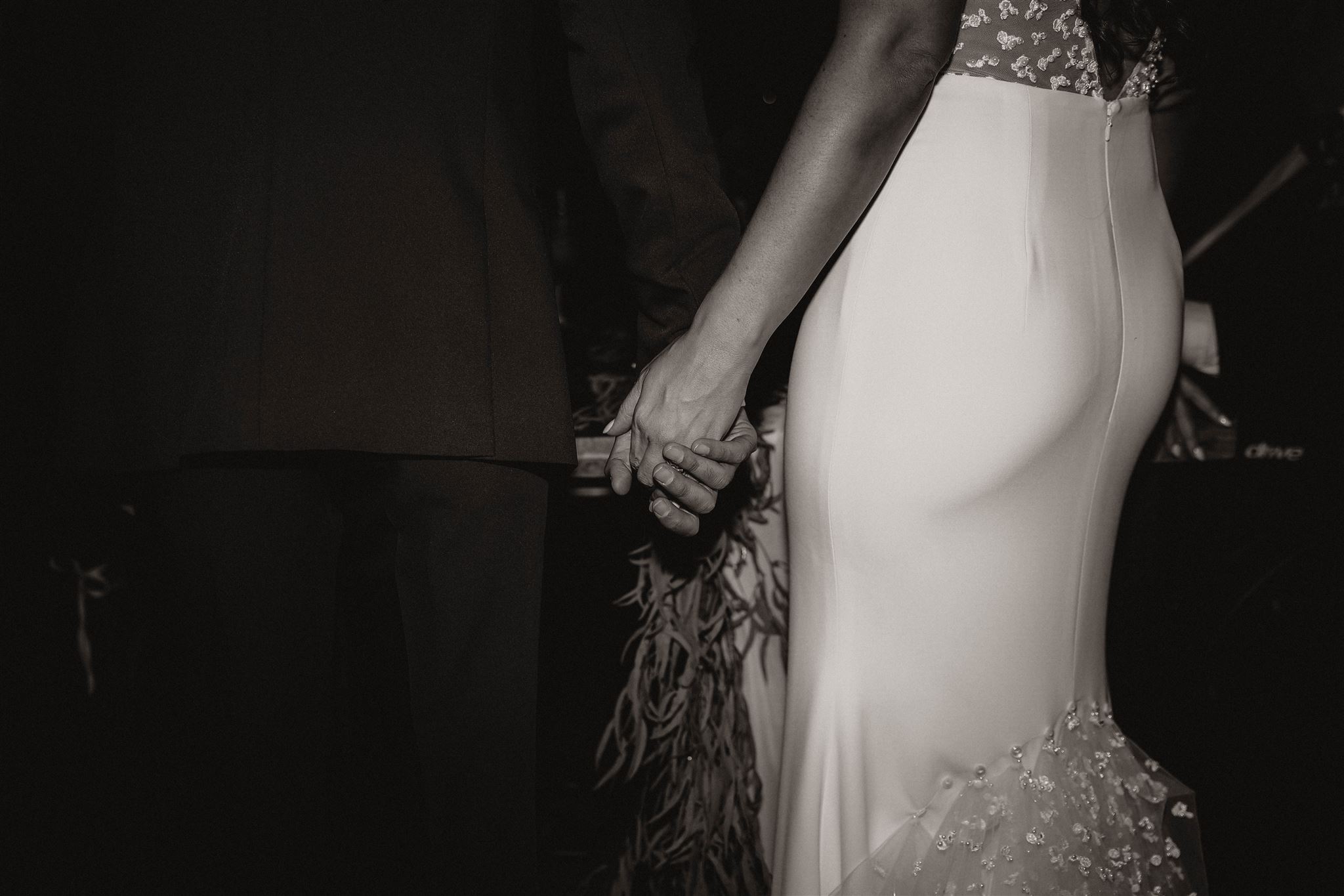 black and white of bride and groom holding hands at fall wedding in colorado 