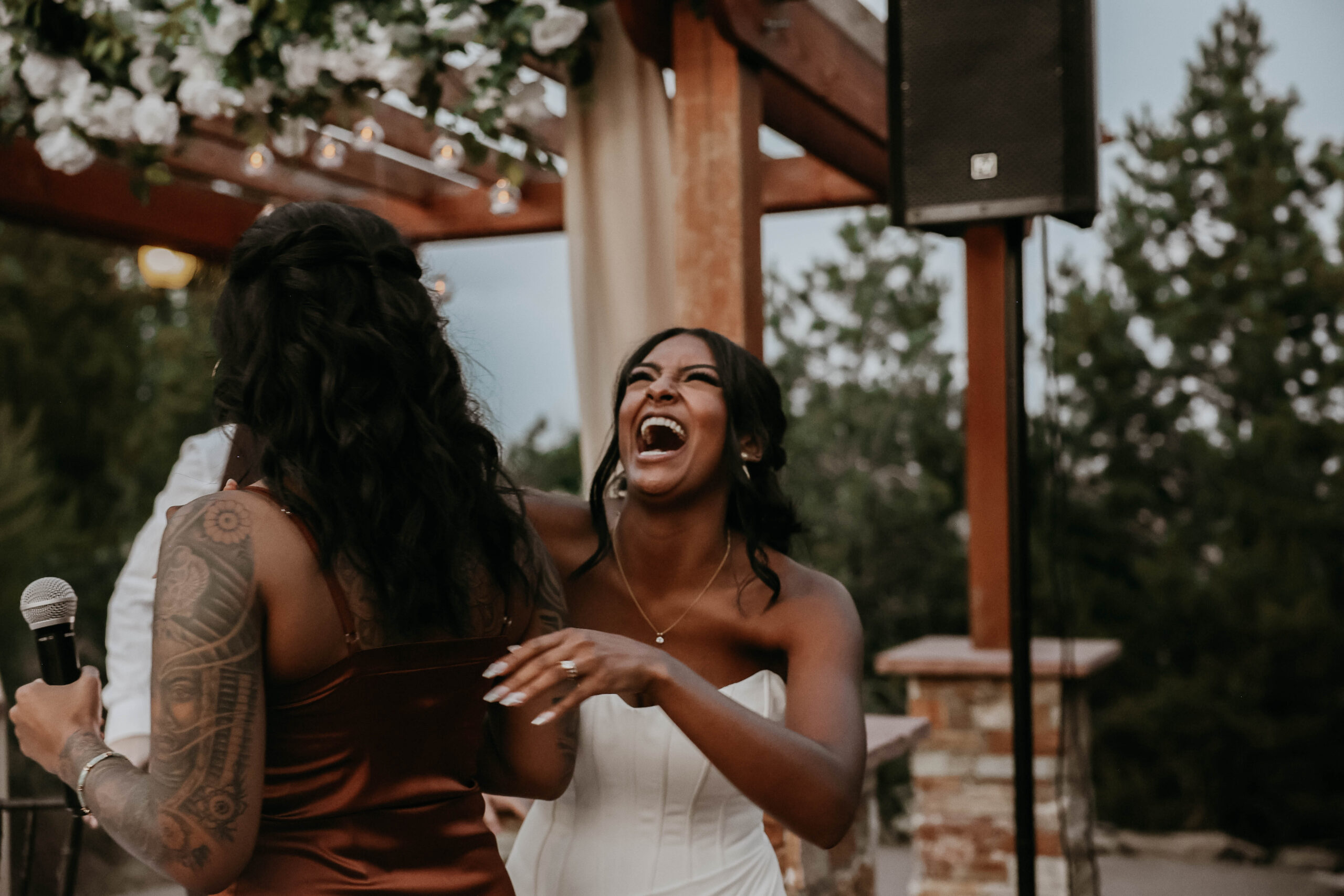 candid of bride laughing at what a bridesmaid said 