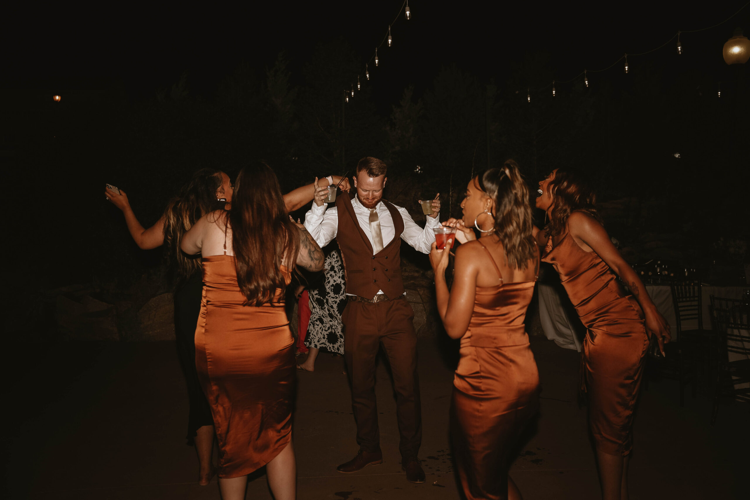 groom and bridesmaids dancing at after party at outdoor wedding in Colorado
