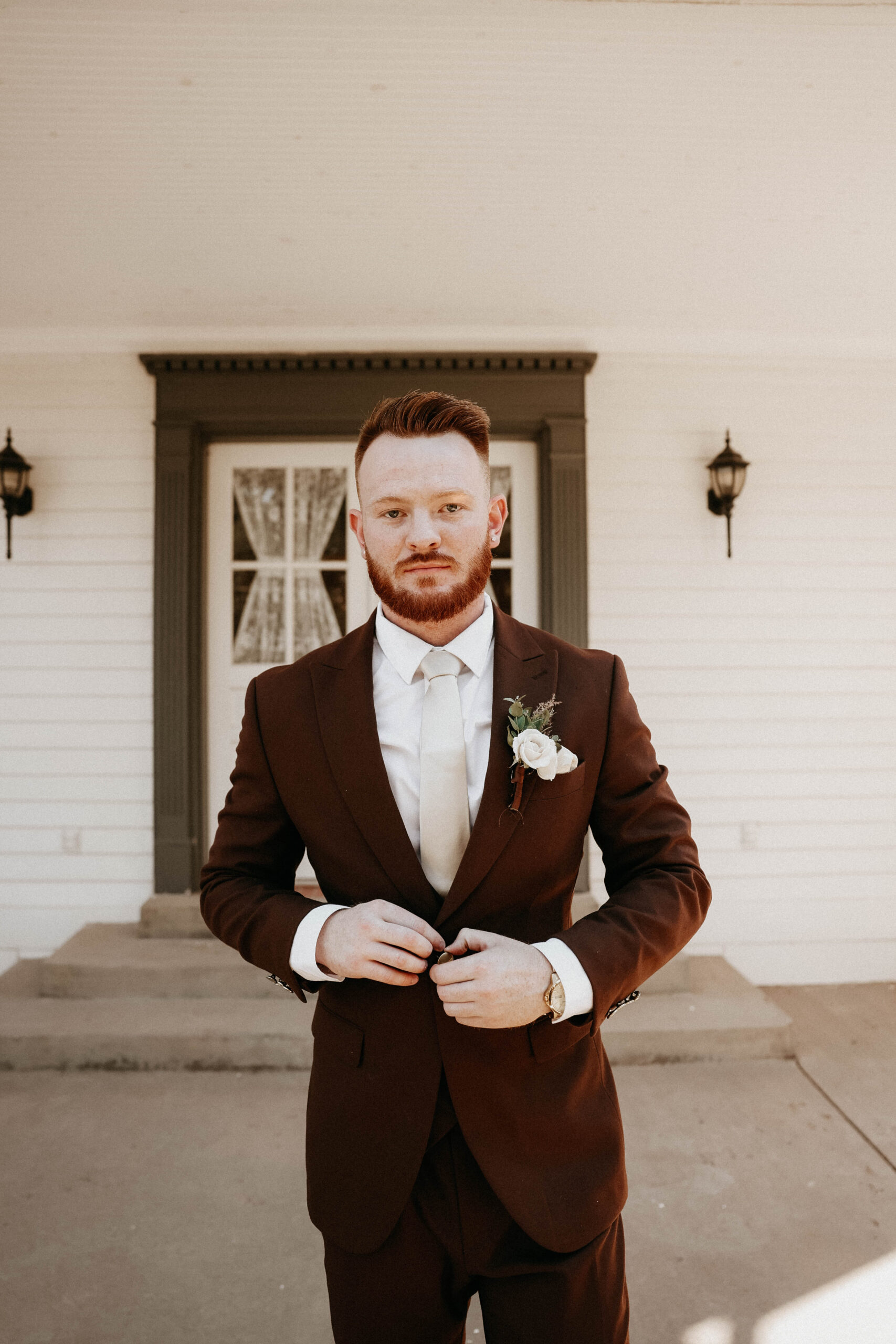 groom portrait in front of a house