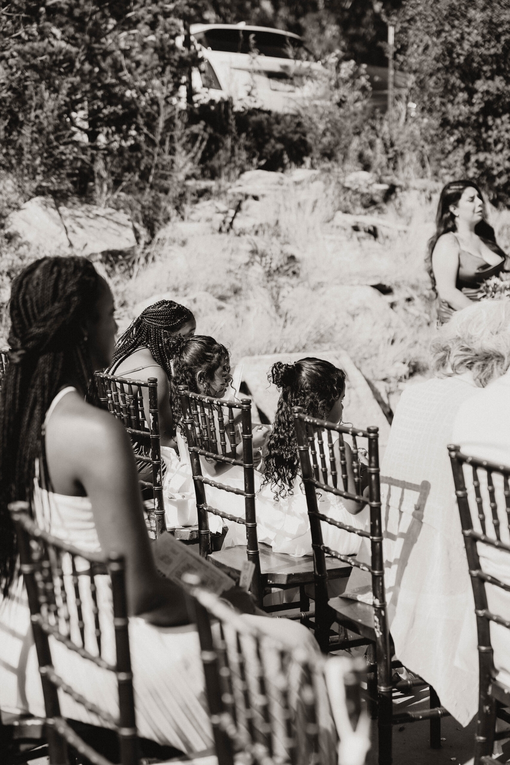 black and white of daughters sitting at ceremony 