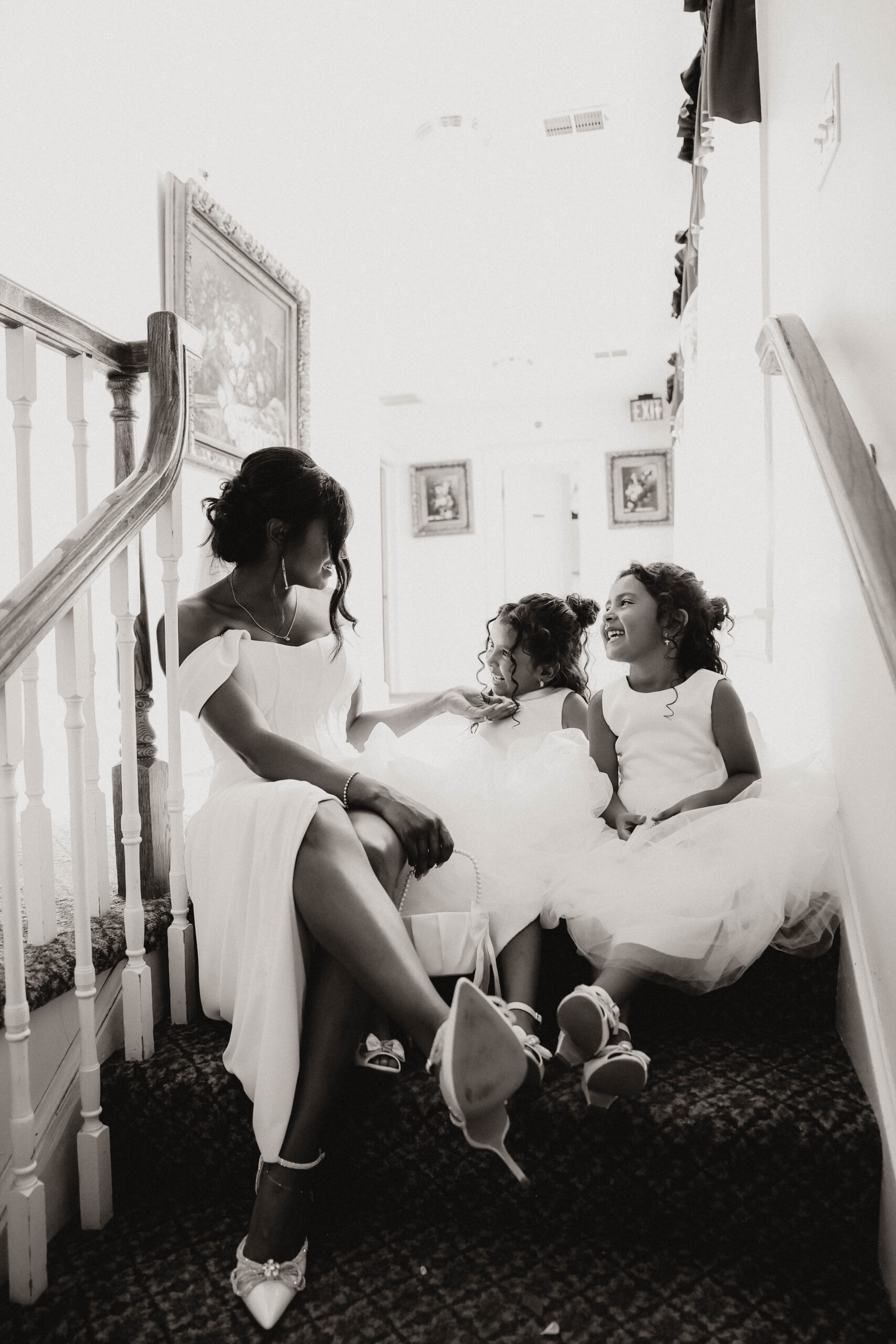 bride and daughters sitting on stair together