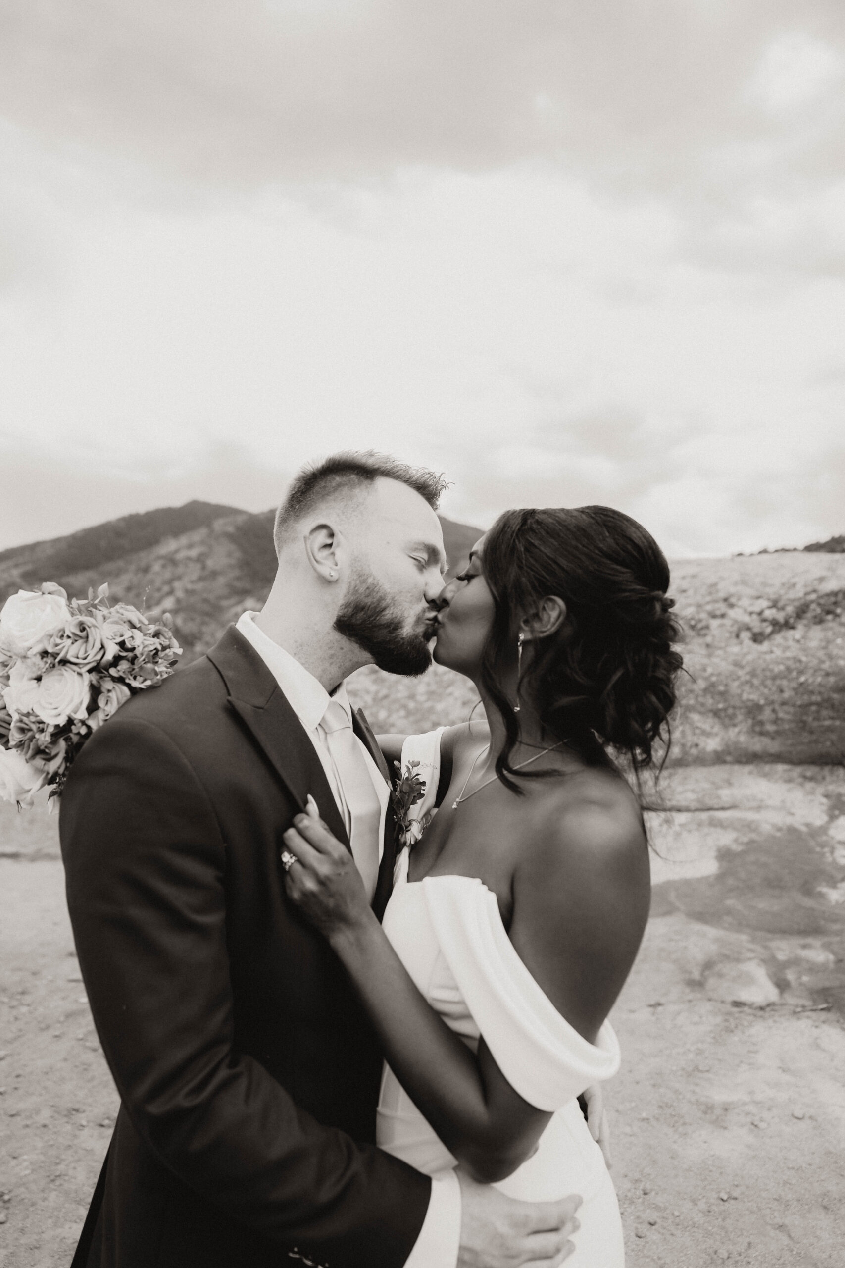 black and white of bridal couple kissing 