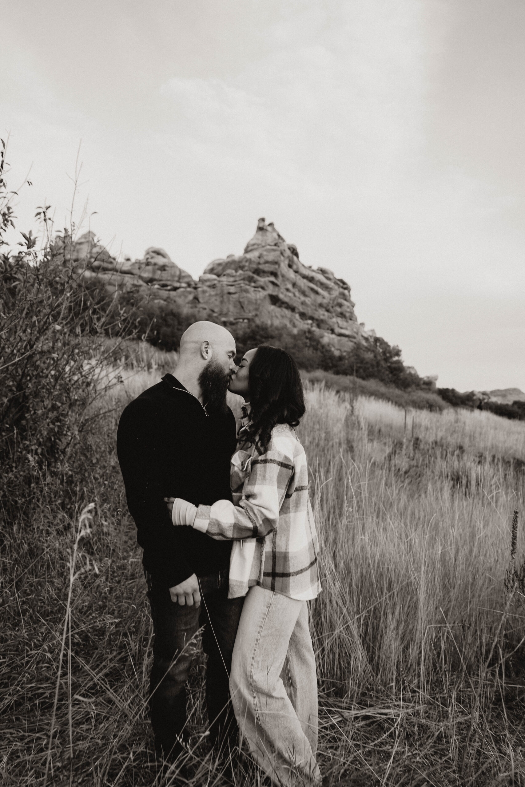 newly engaged couple kissing in the tall dried grass 