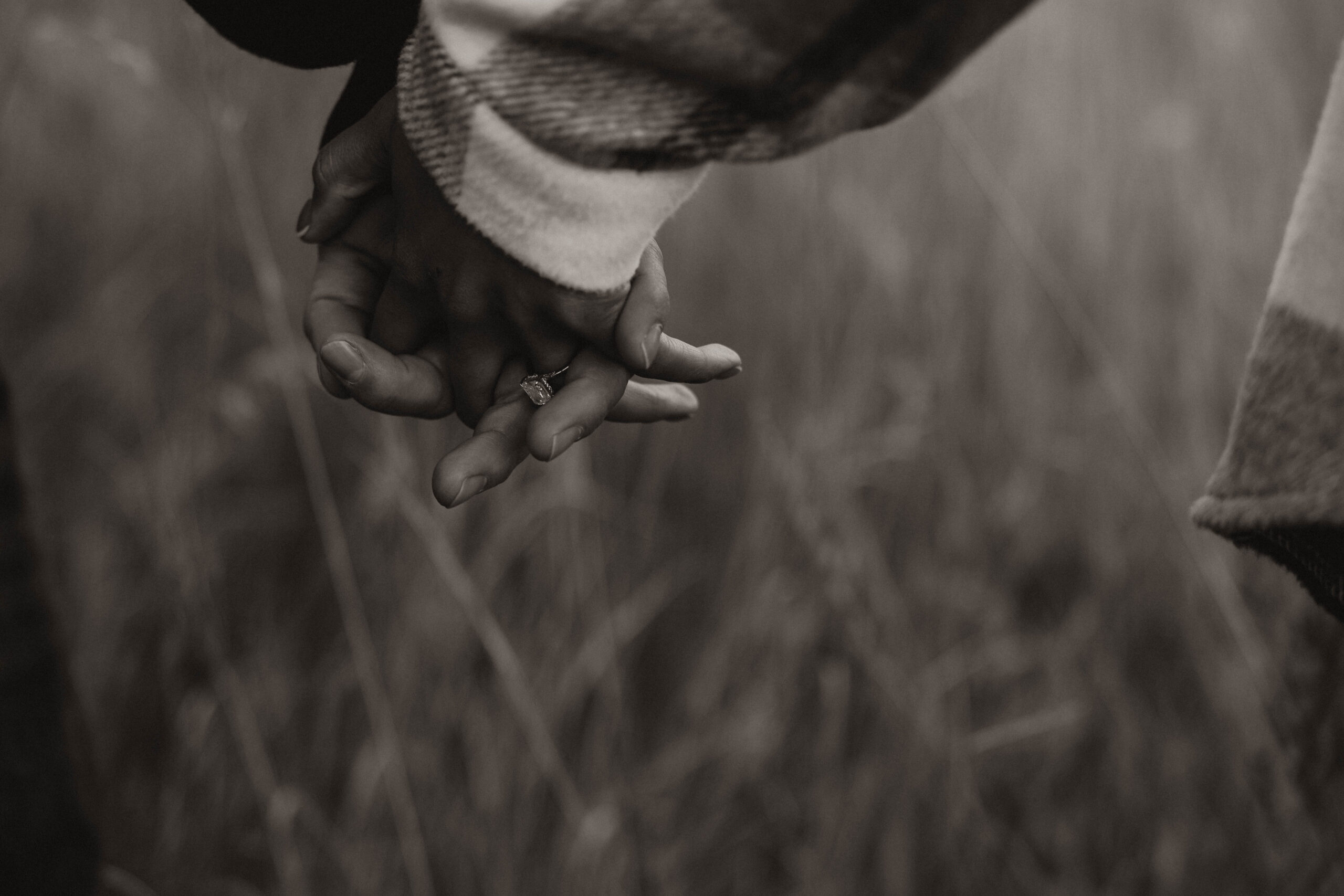 close up of couple holding hands during engagement session 