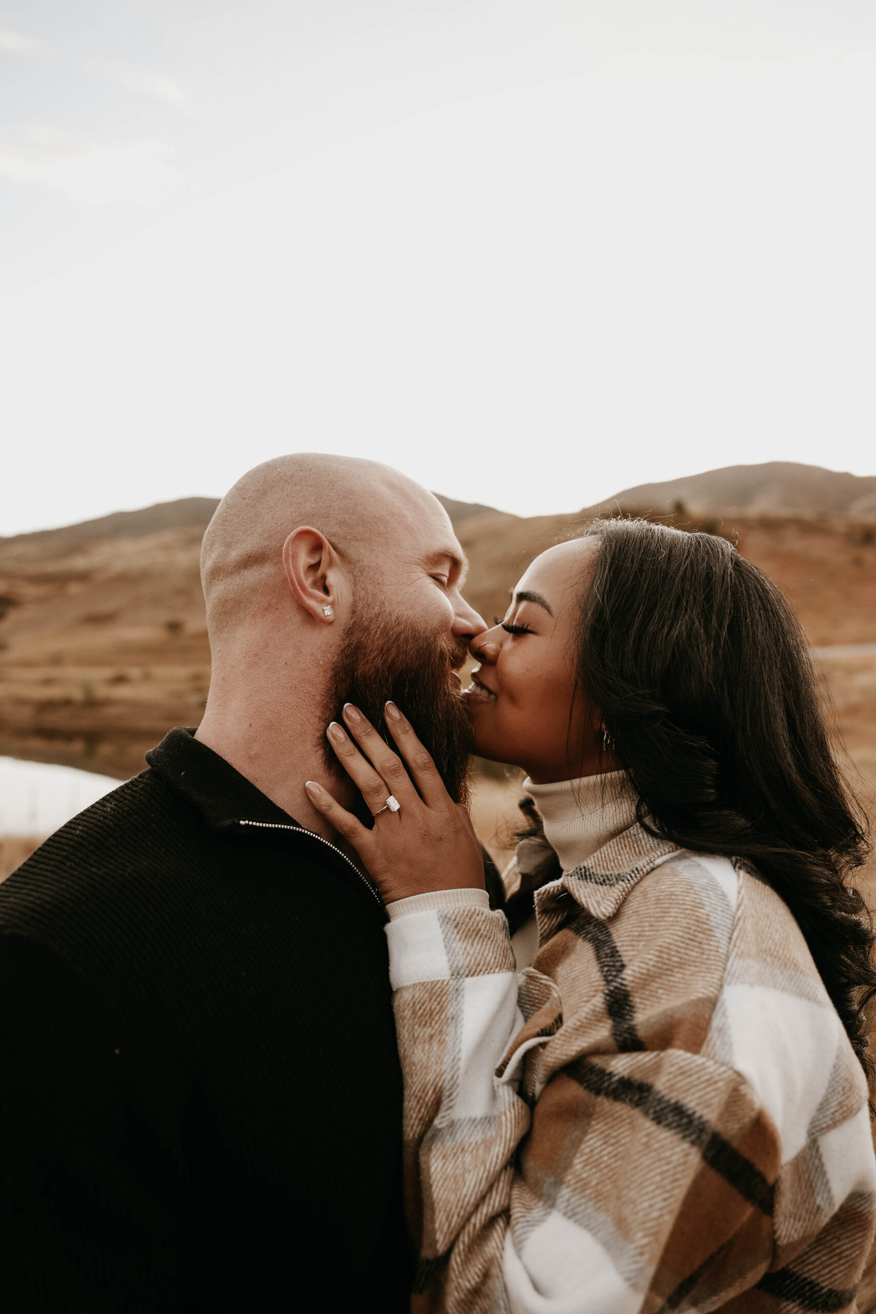 photographers picture of newly engaged couple about to kiss during their engagement photos 
