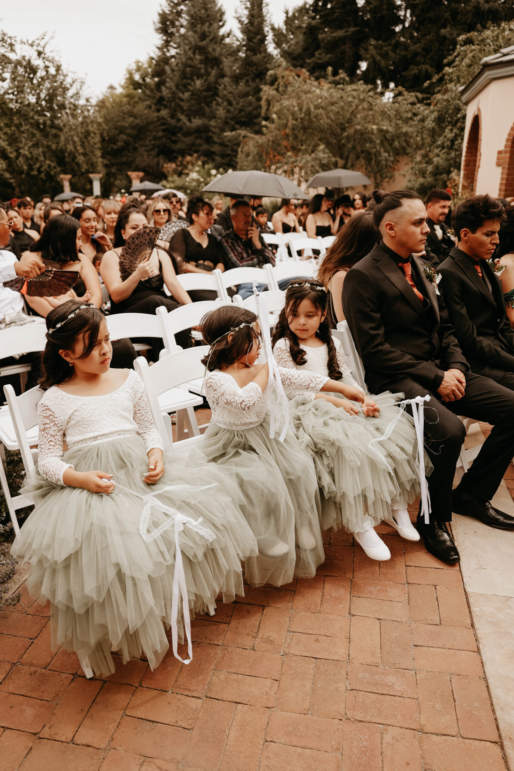 flower girls sitting in chairs during the ceremony 