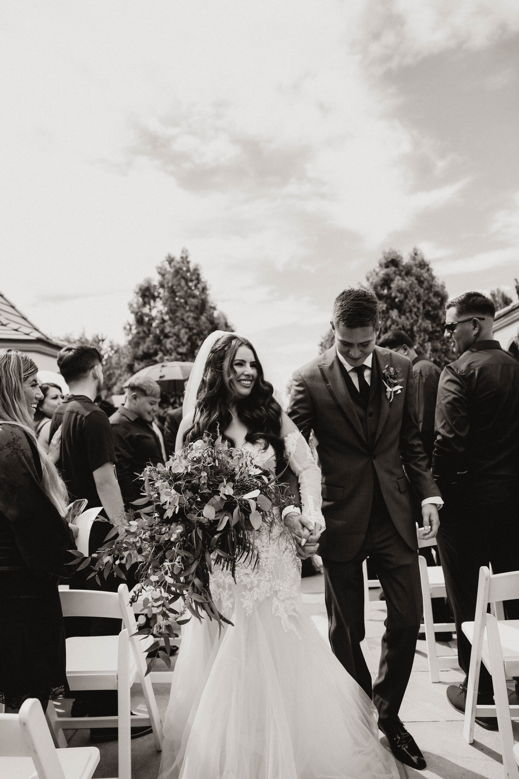 candid black and white of bridal couple walking down the aisle after the ceremony 
