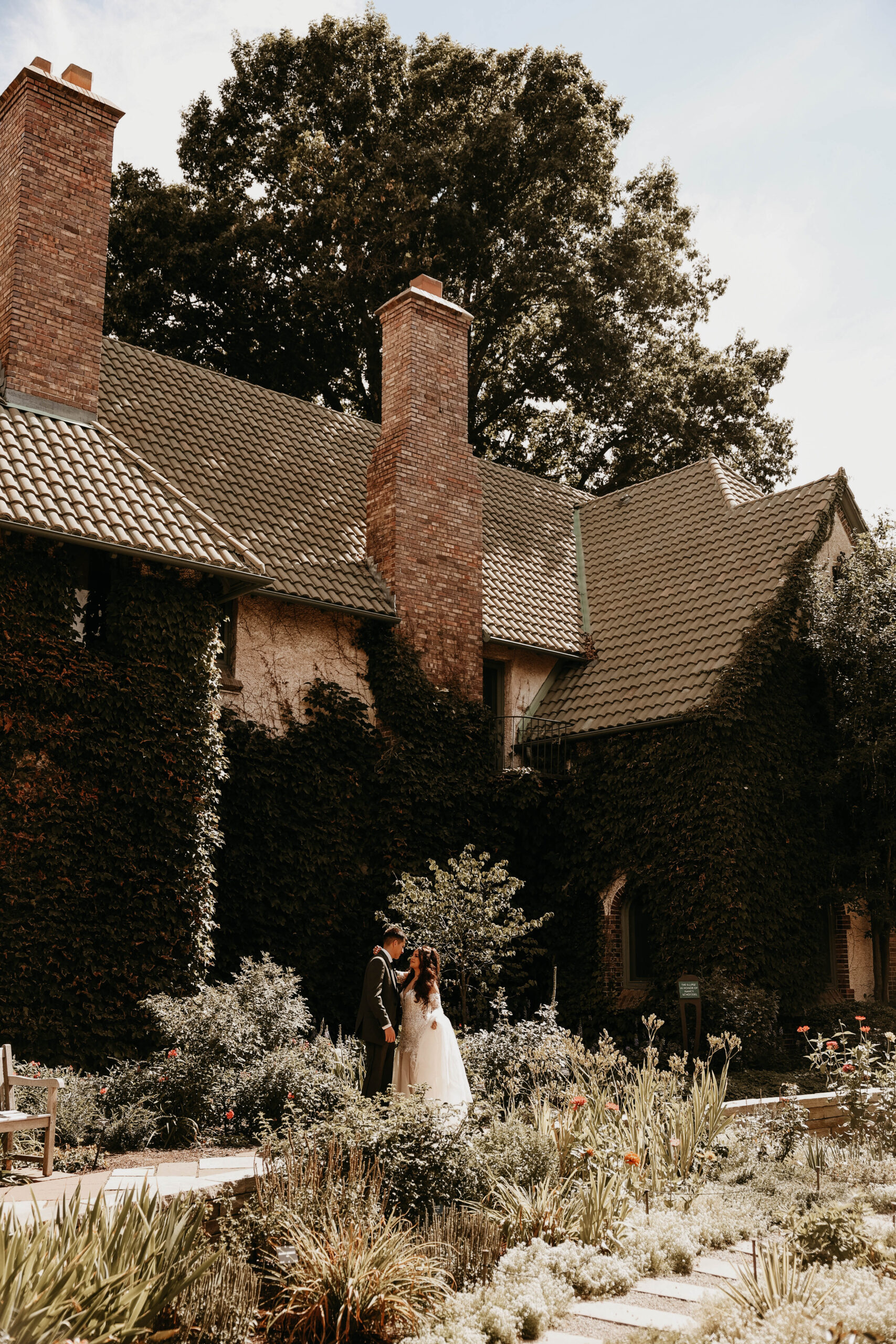 bride and groom portrait in front of beautiful building with gardens surrounding 