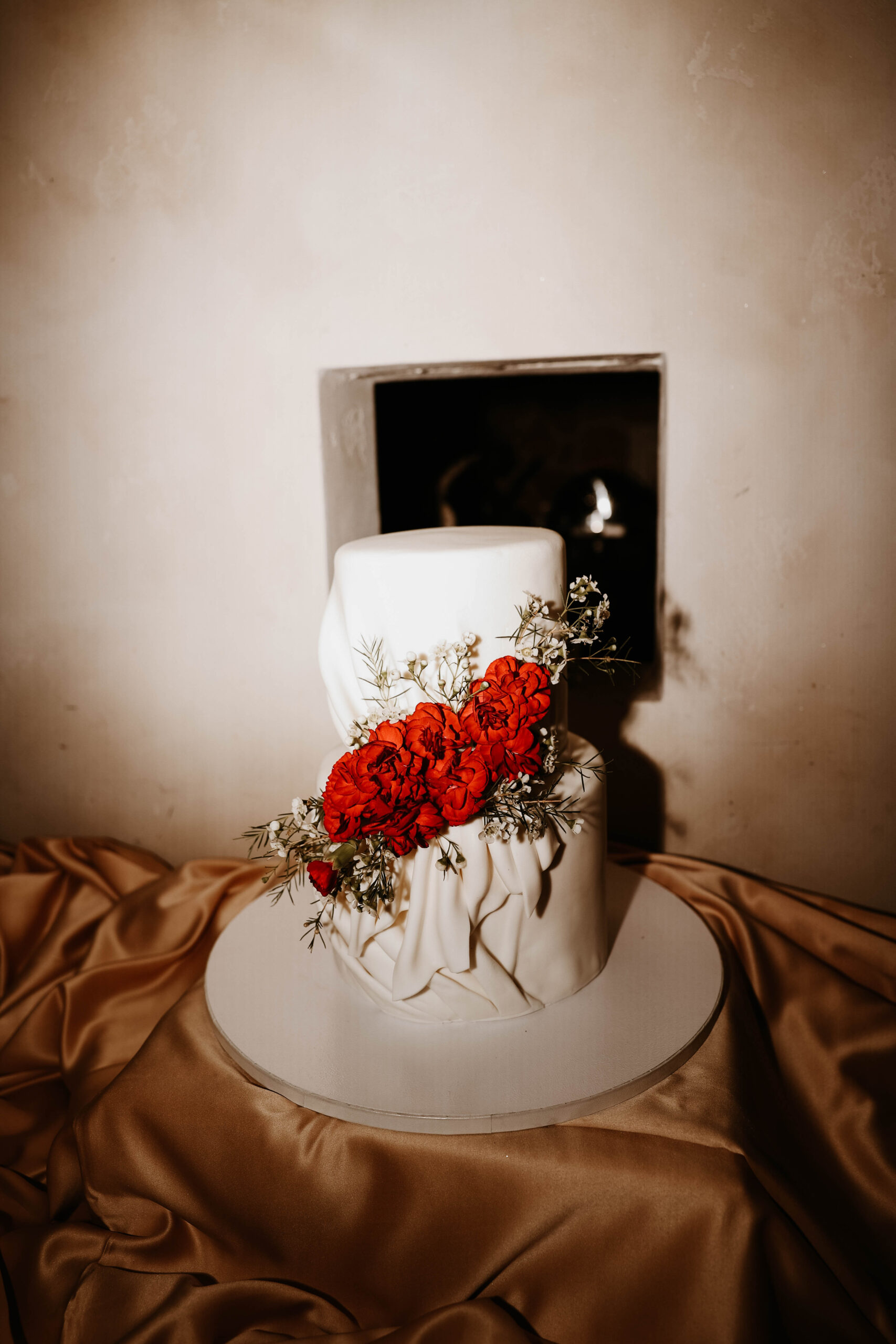 white wedding cake with red flowers 
