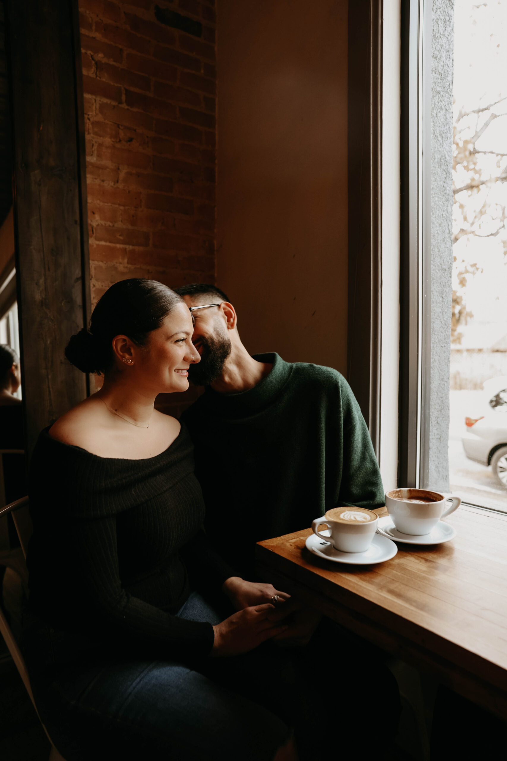 fiance kissing other kiance at the coffee shop during their engagement photos 