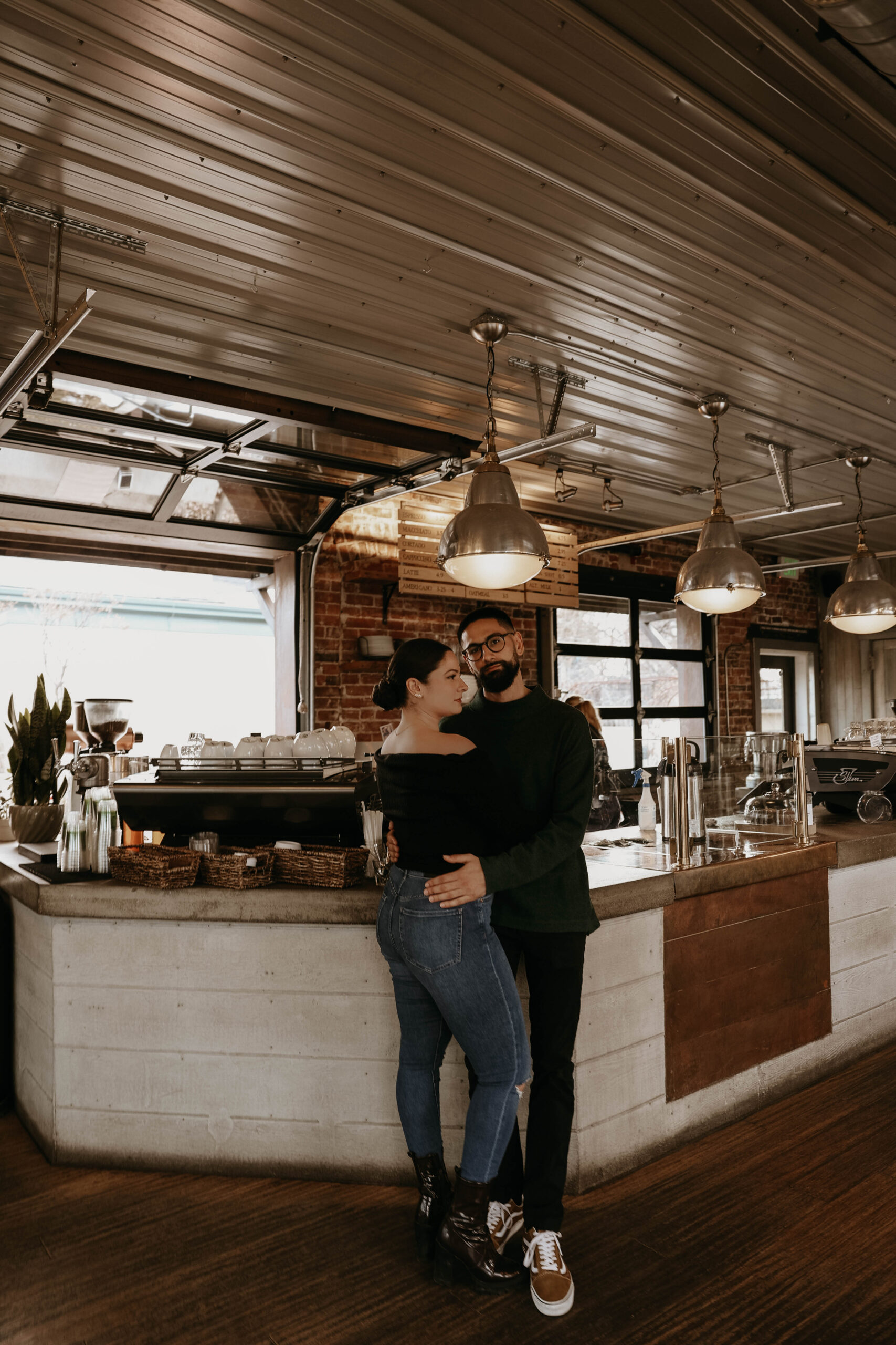 engaged couple at their engagement photo location, a coffee shop in denver