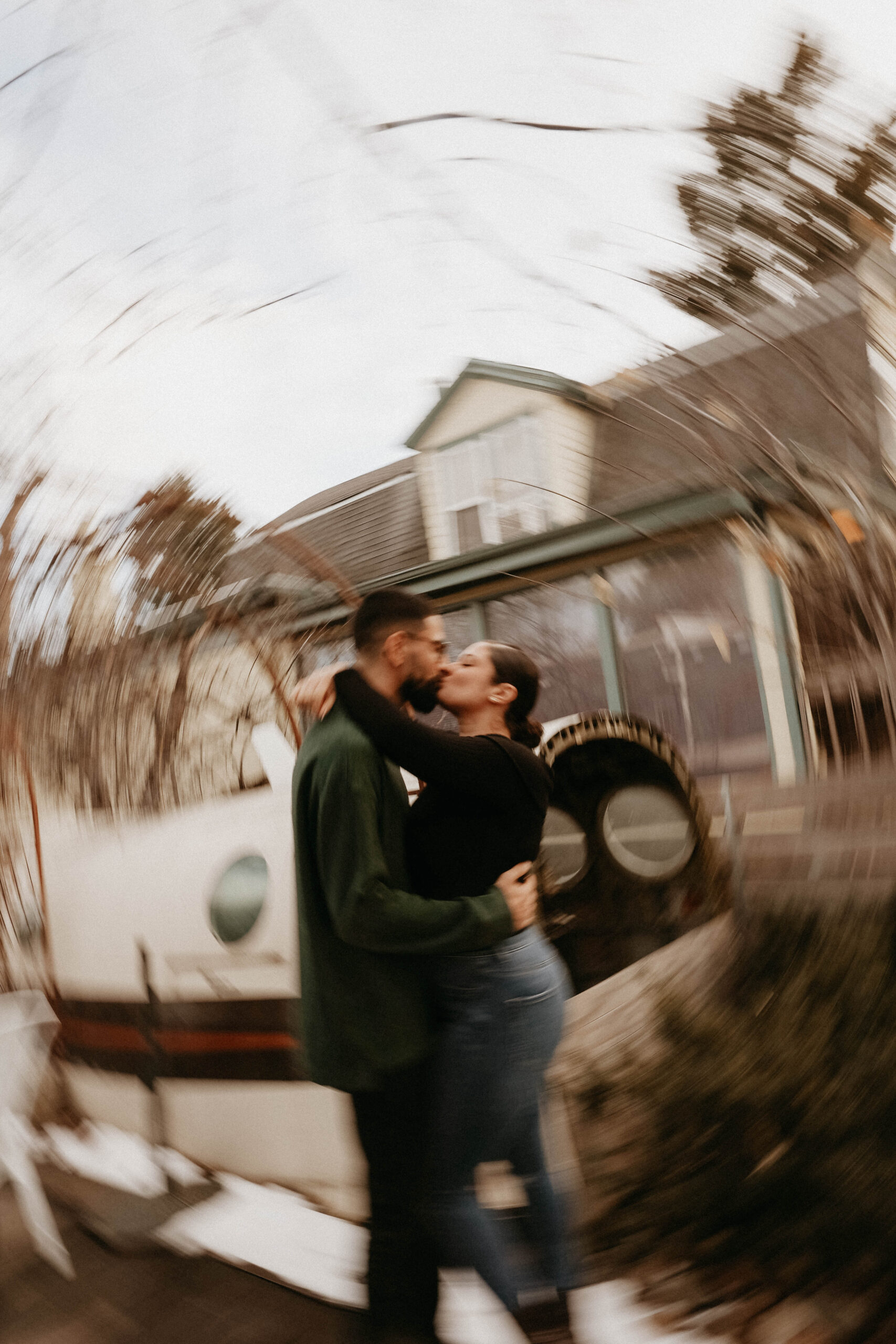 blurry photo of couple kissing by a plane at engagement photo location