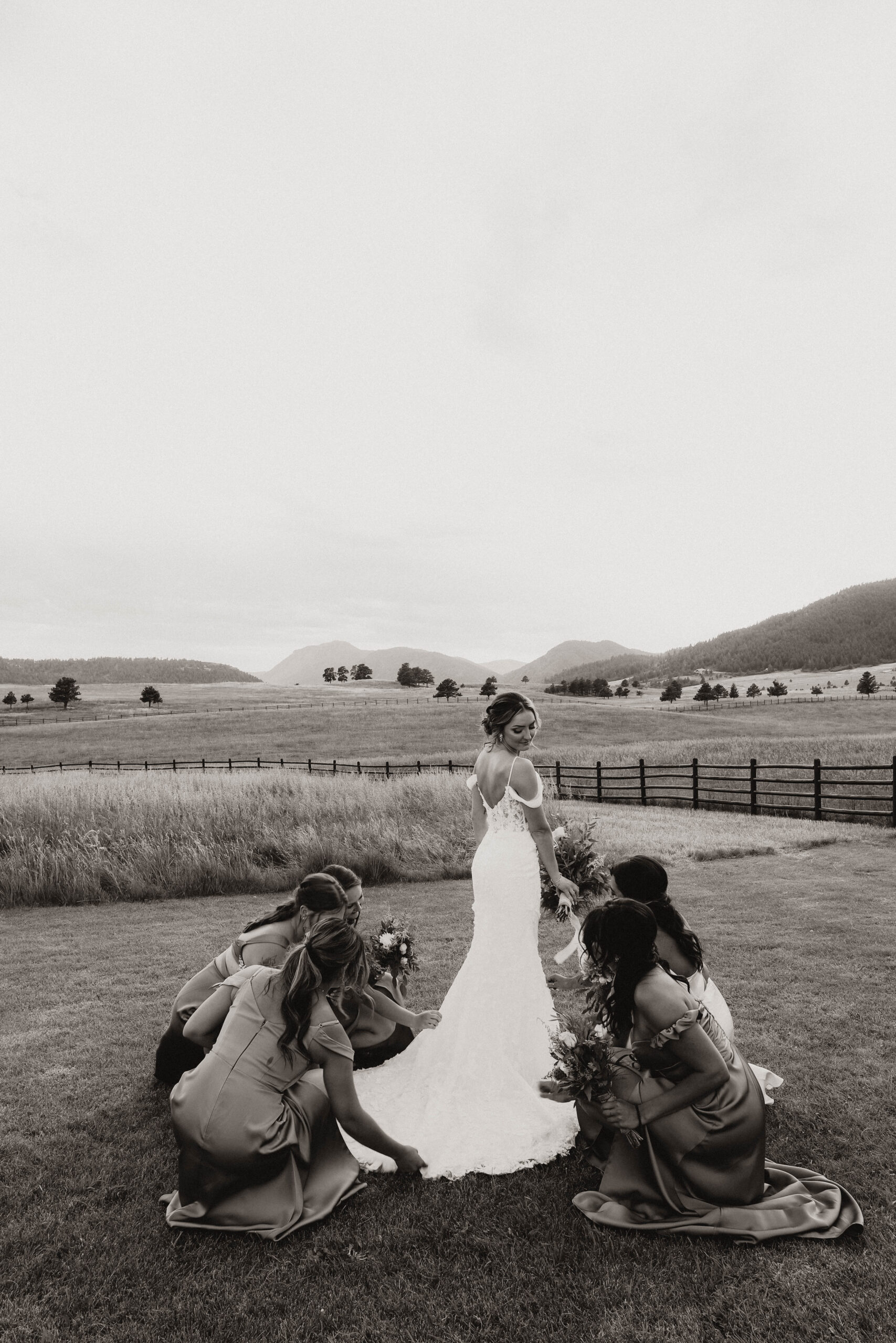 bridesmaids helping bride with dress 