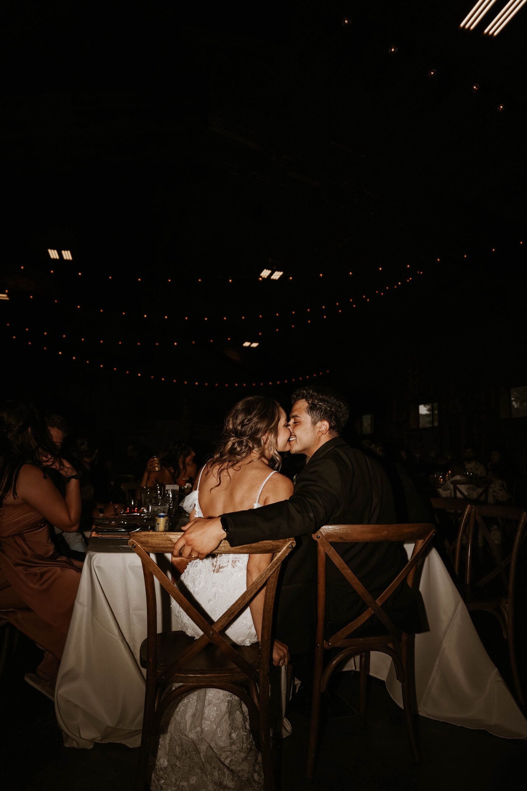 bride and groom kissing at wedding reception 