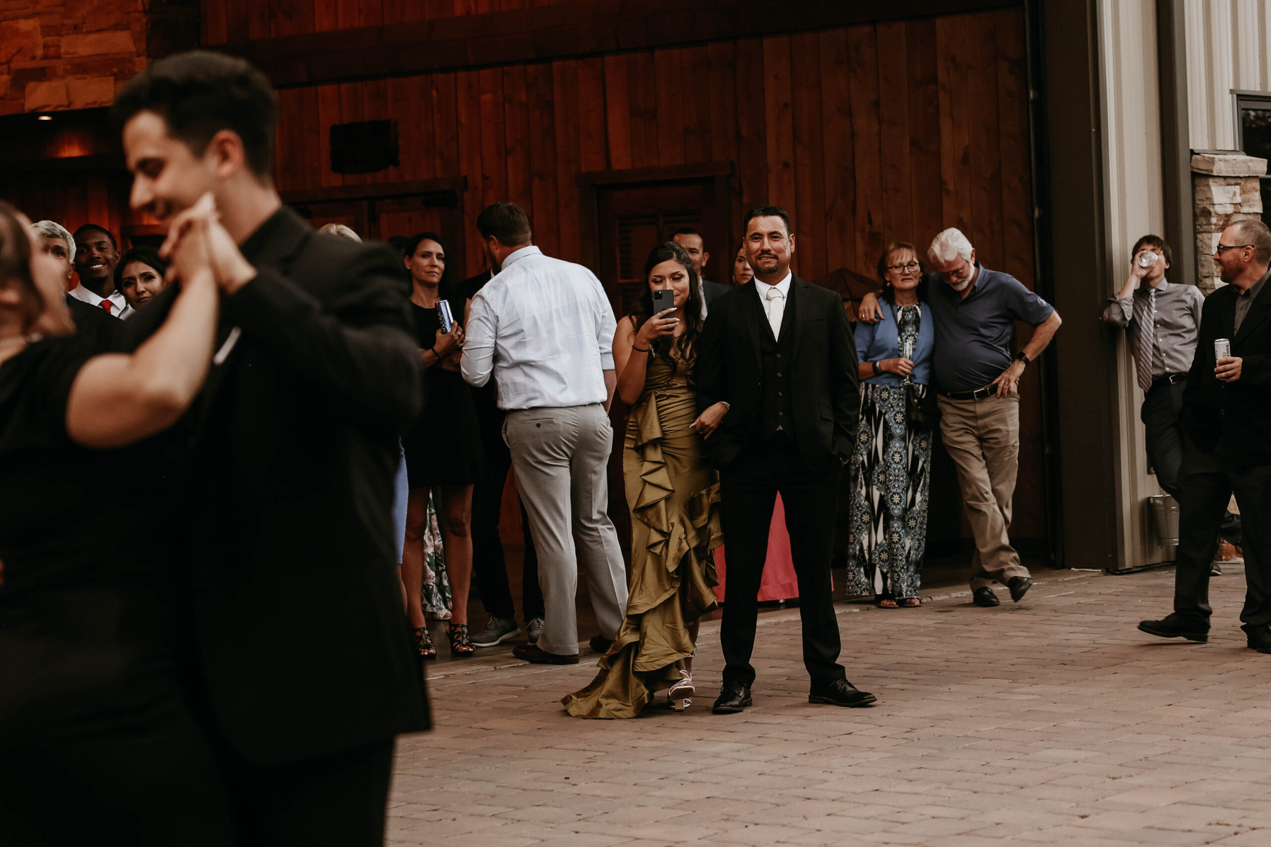 groom dancing with mother while wedding guest take a photo 
