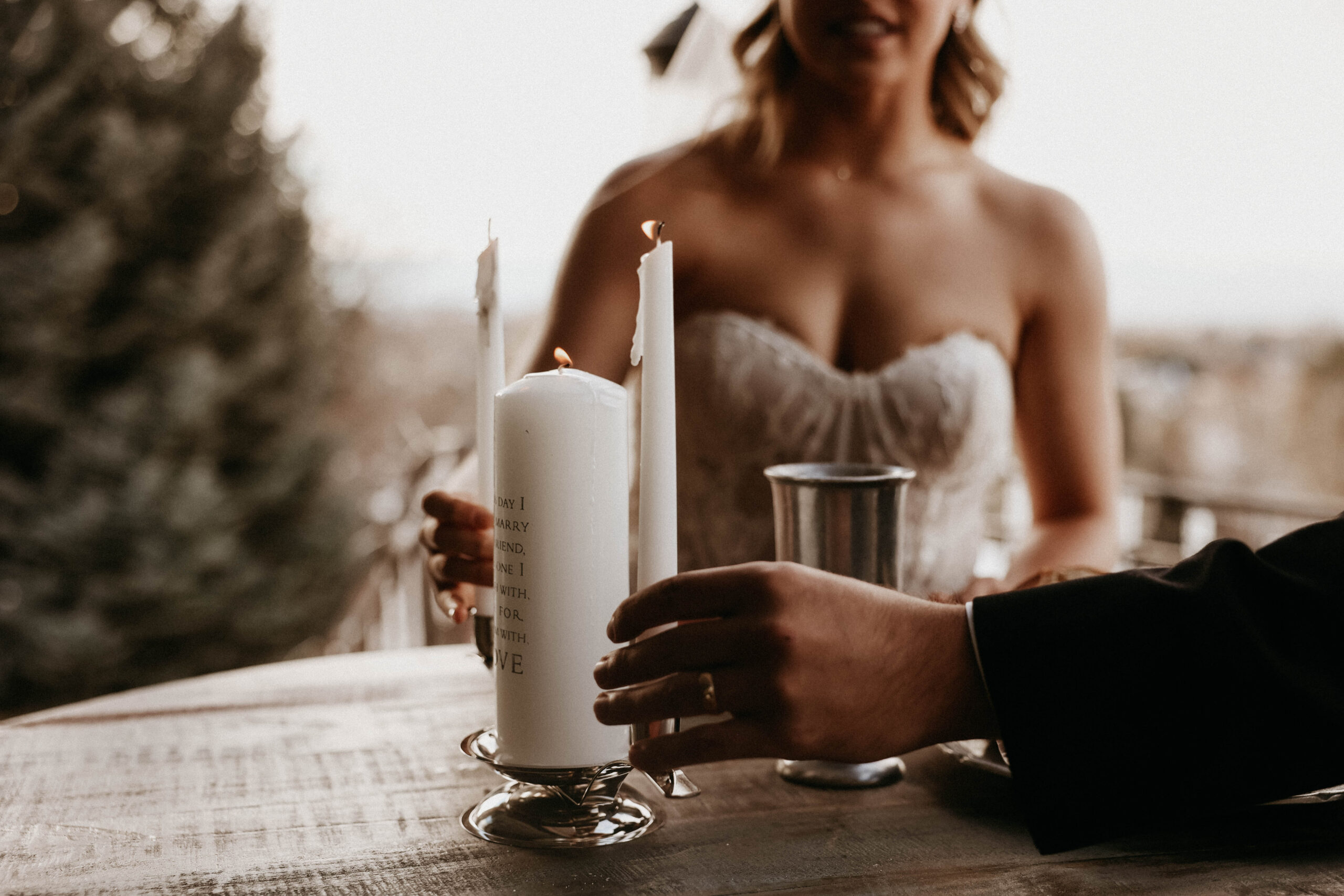 bridal couple lighting a candle during their ceremony 