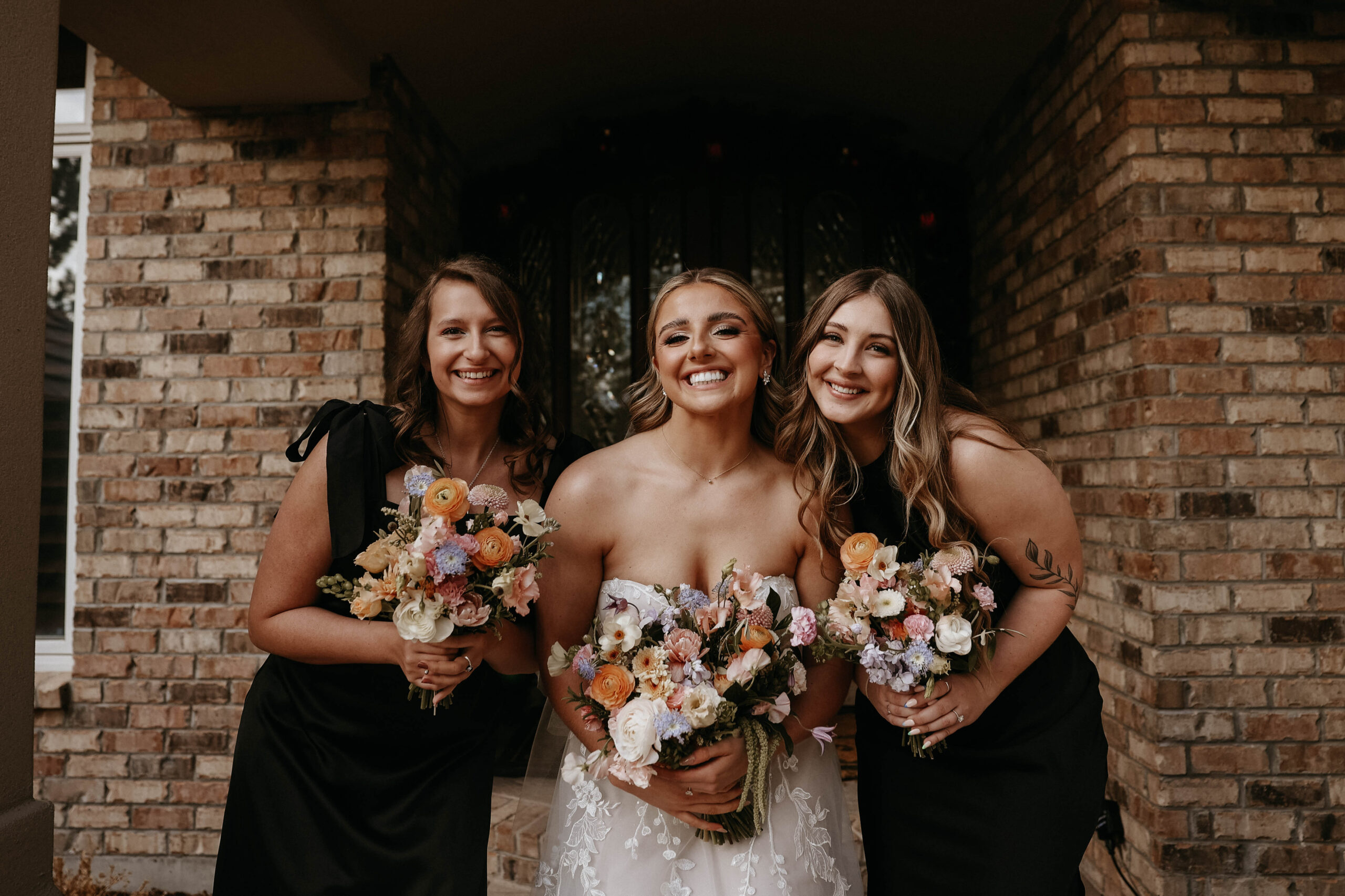 bride and bridesmaids holding their colorful wedding bouquets 