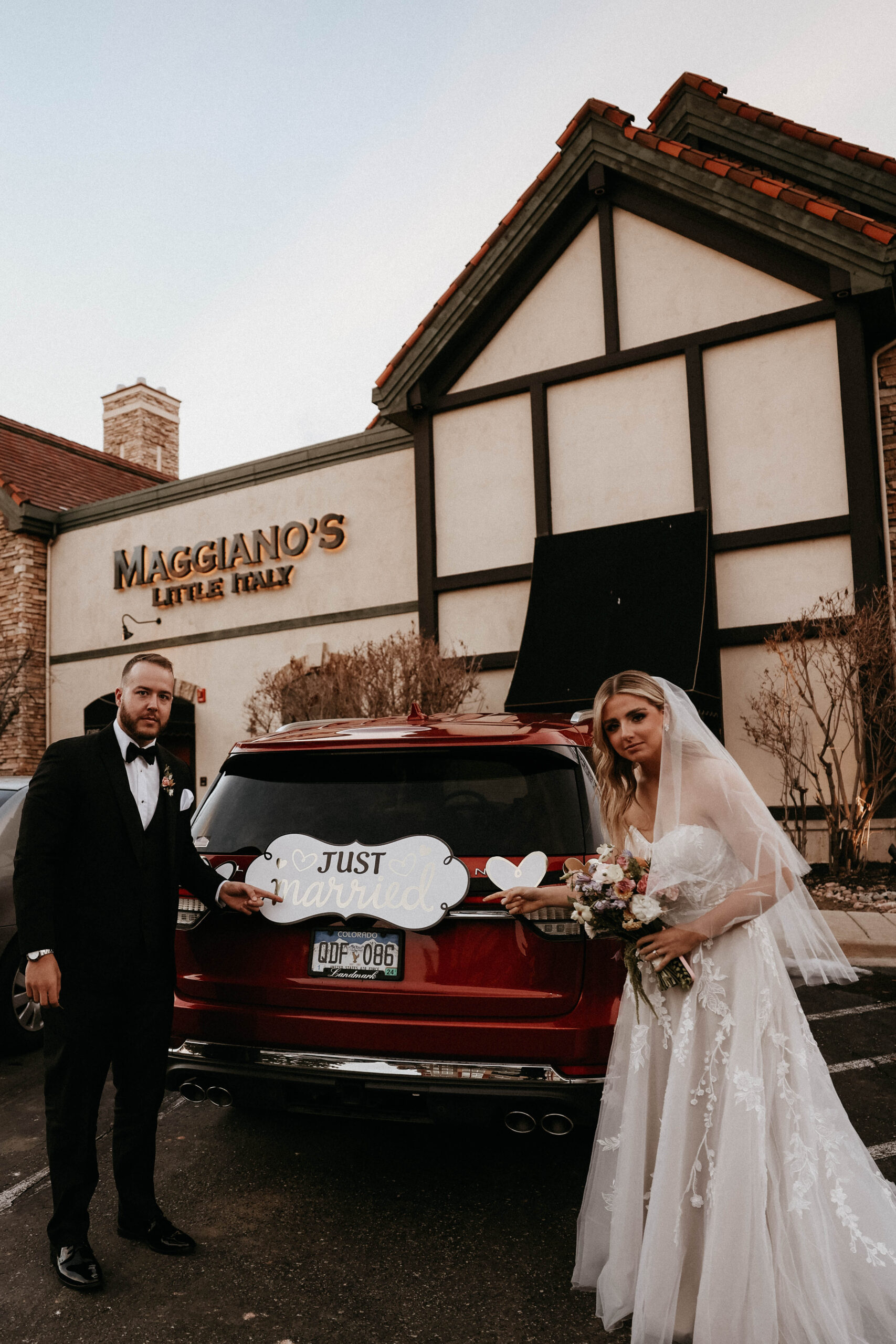 bridal couple next to their car with just married sign 