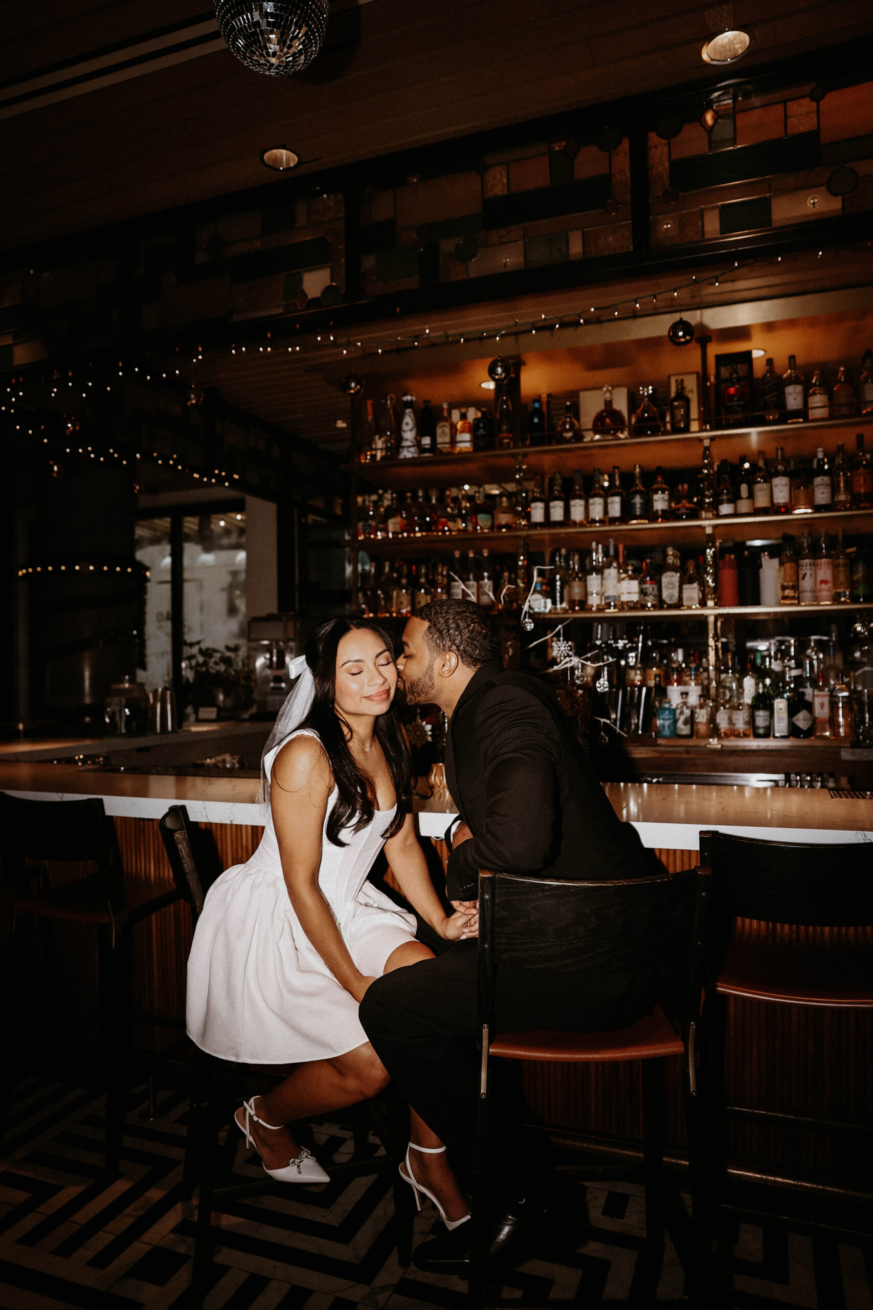 fiance kissing other fiance on the cheek at the bar 