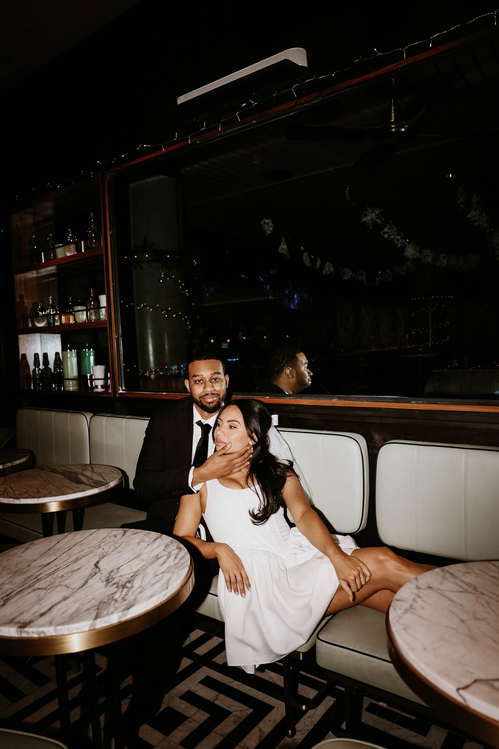 newly engaged couple sitting at a table in a bar during their unique engagement shoot