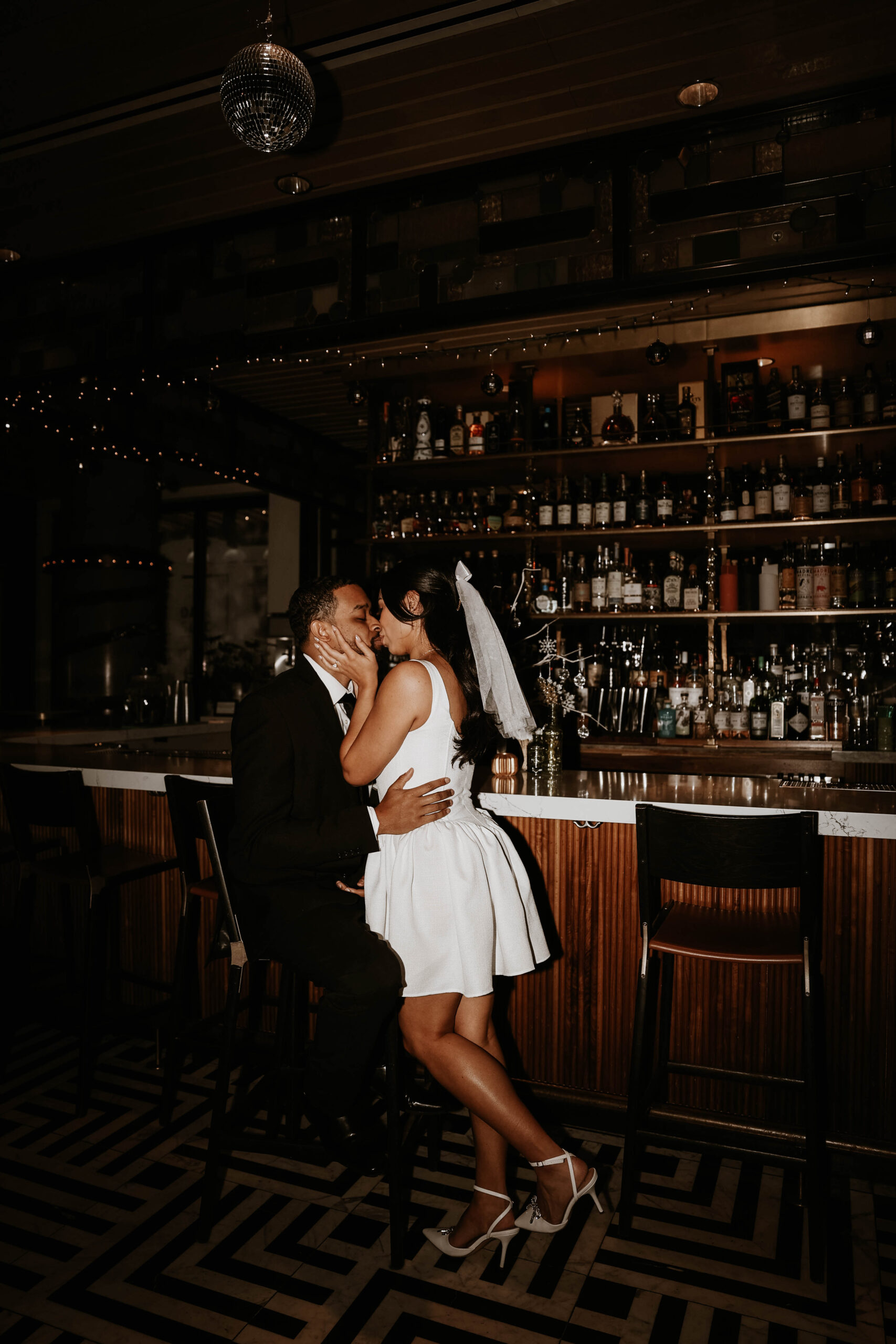 engaged couple kissing at the bar expressing their unique engagement shoot ideas