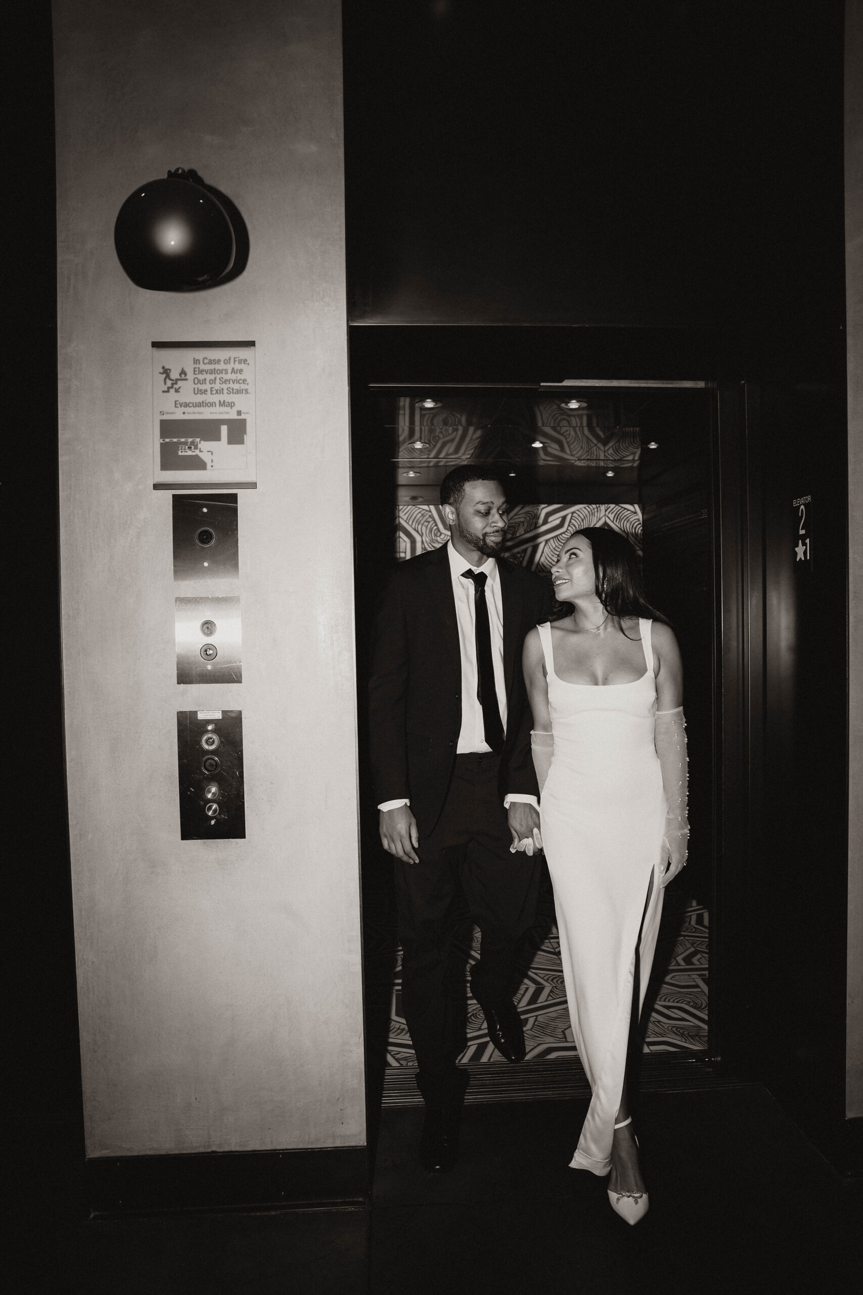 newly engaged couple walking out of an elevator expressing their unique engagement shoot ideas
