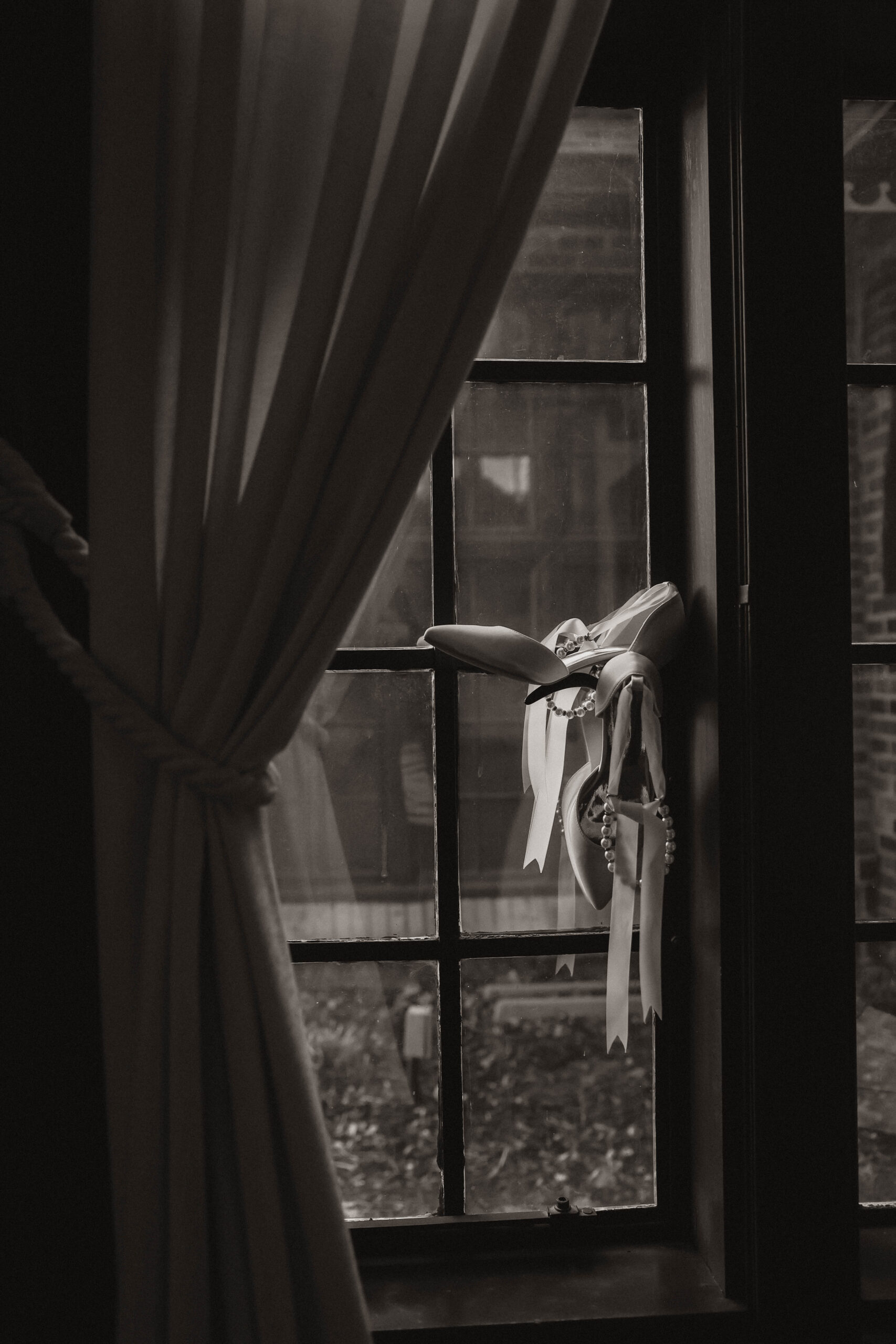 bride's shoes hanging in a window 