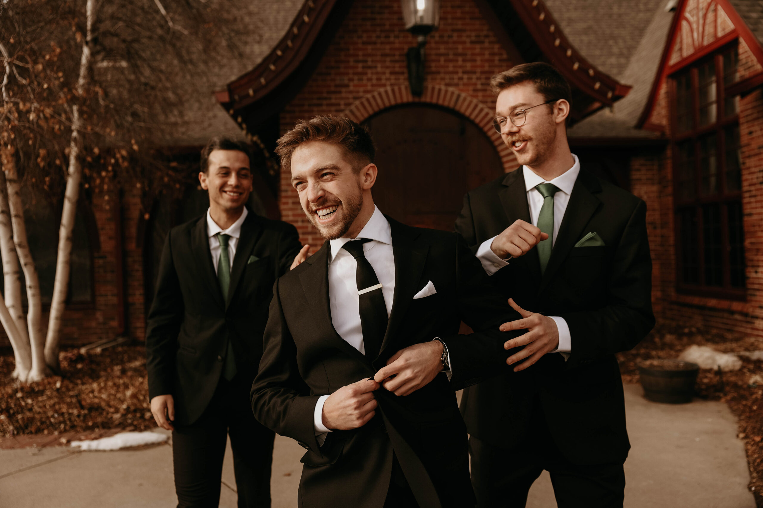 groom and groomsmen walking and laughing together 