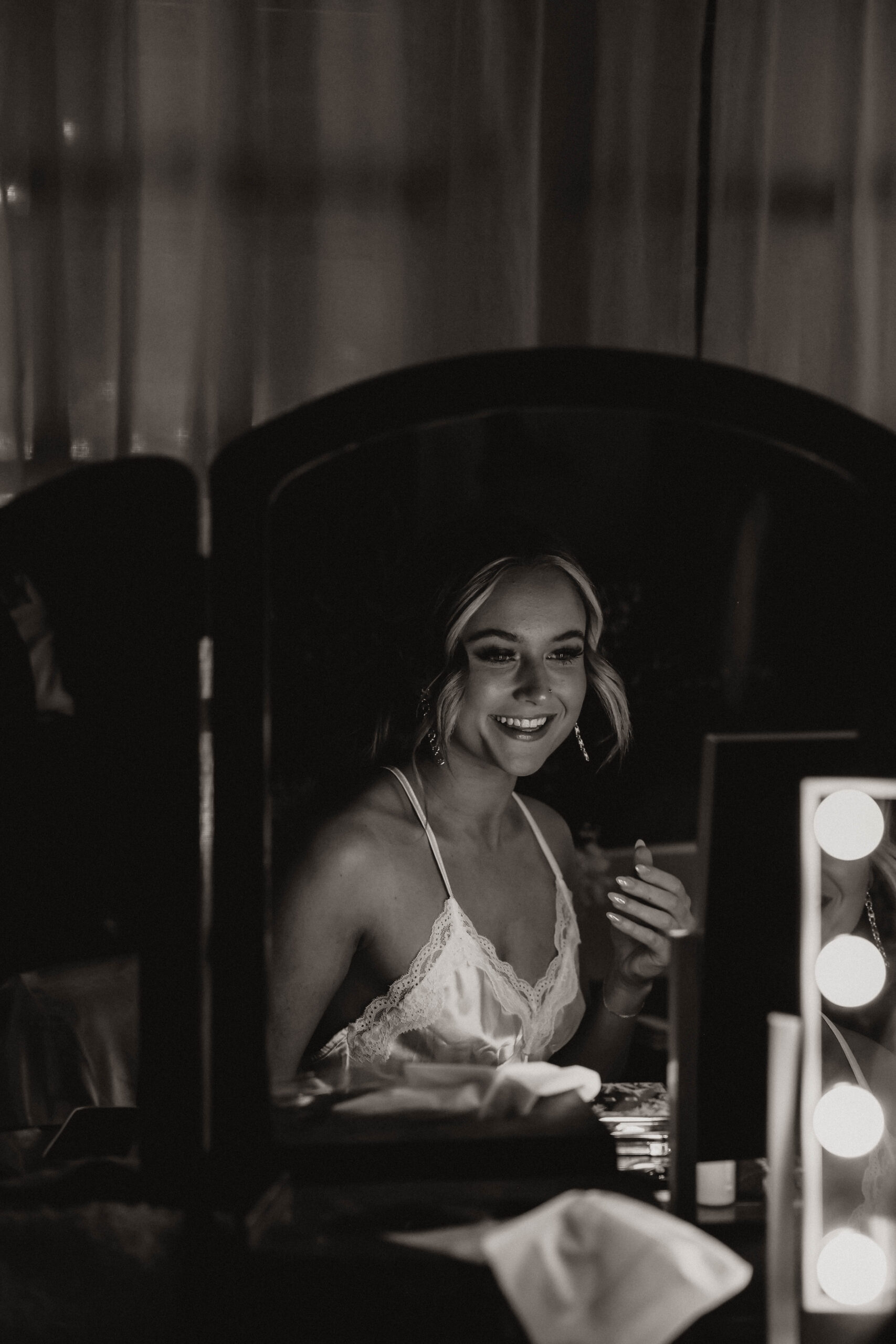 bride smiling into the mirror 