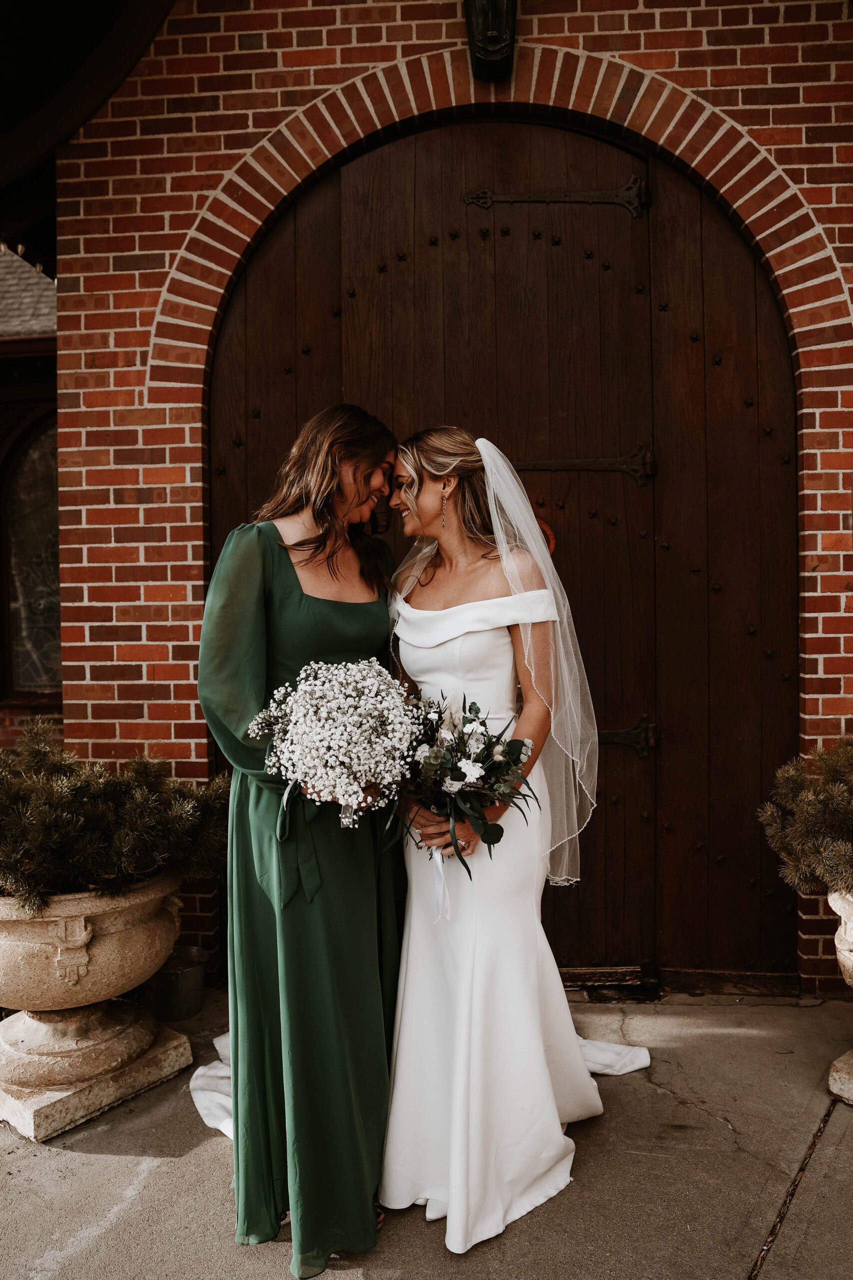 bride and a bridesmaid putting their foreheads together 