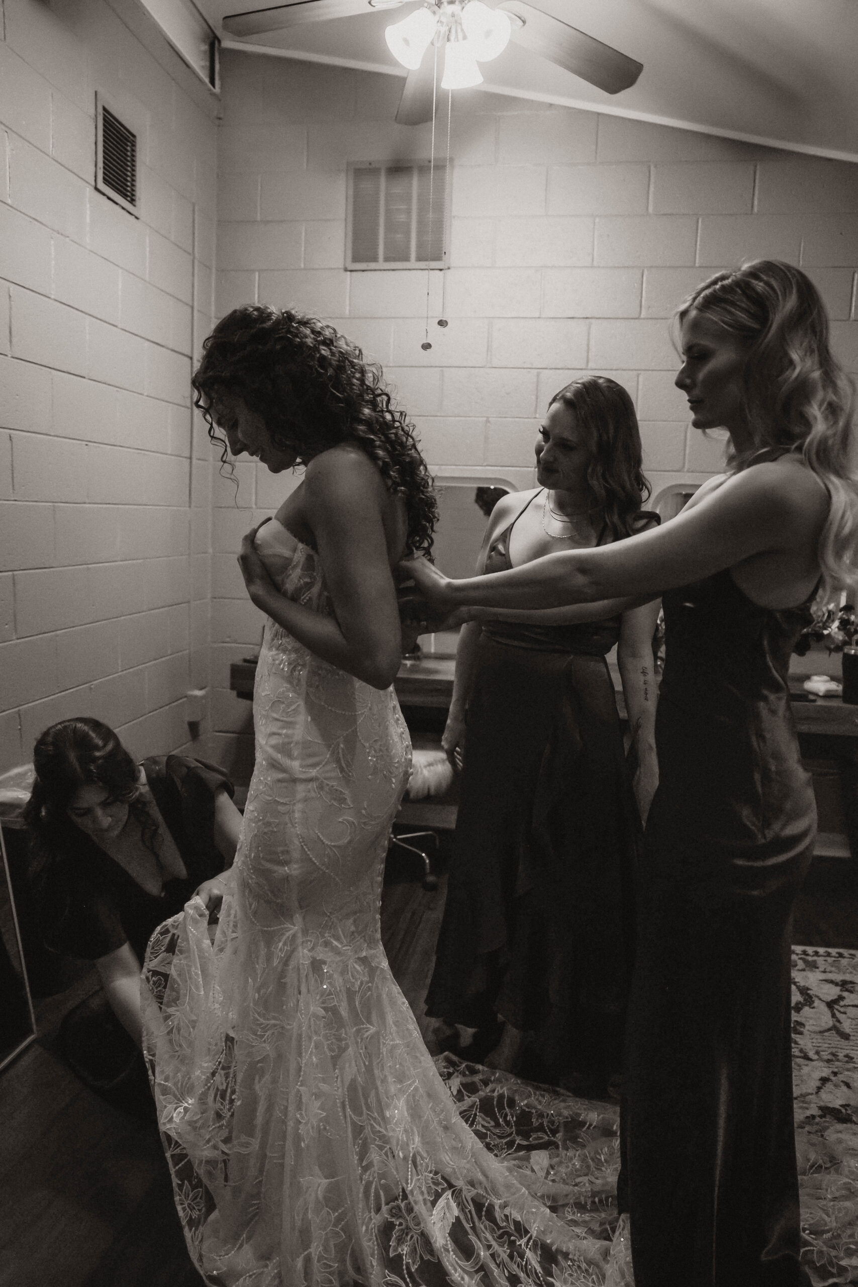 meaningful wedding moments of bridesmaids zipping up bride's dress