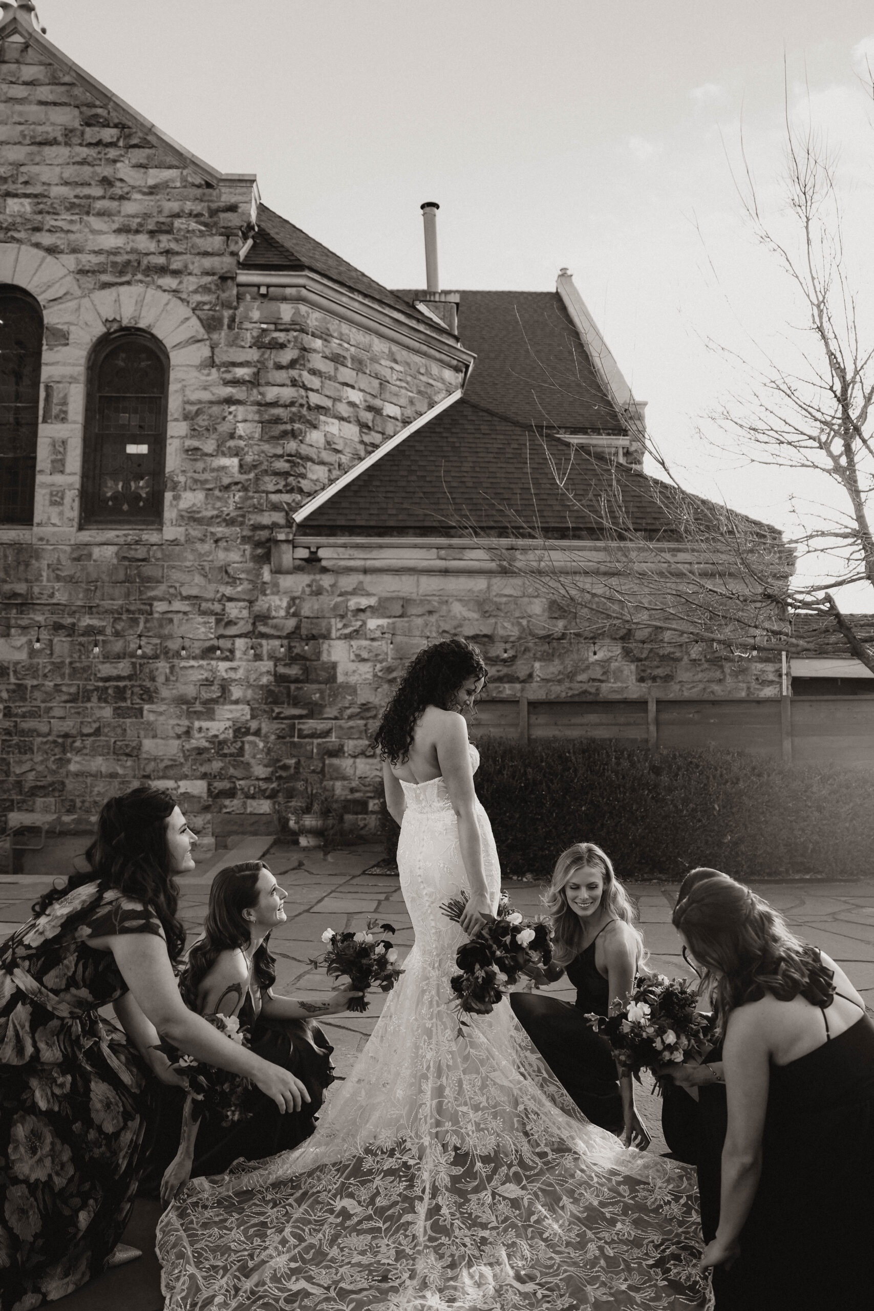 meaningful wedding moments of bridesmaids helping bride with her dress