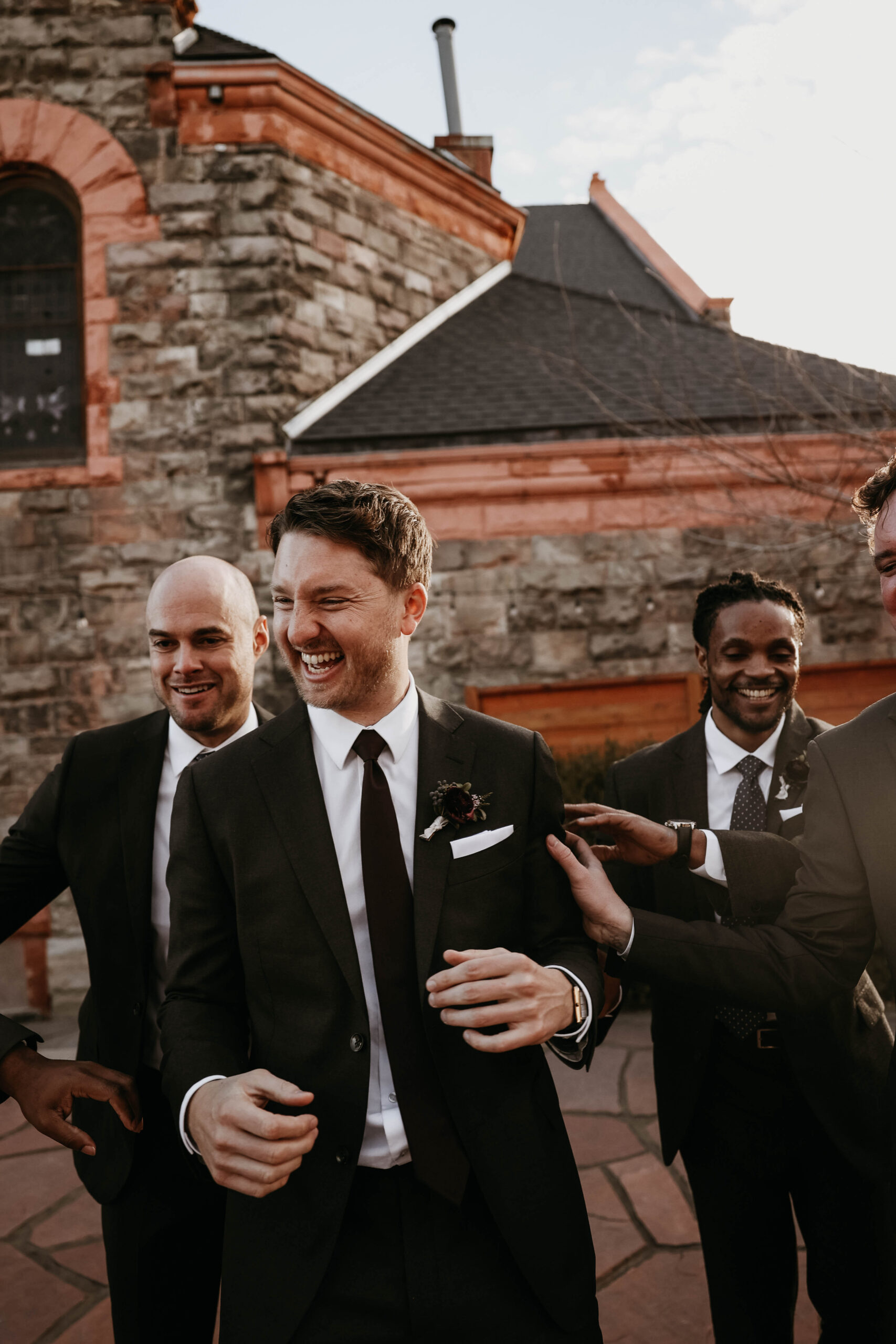 meaningful wedding moments of the groom laughing with his groomsmen