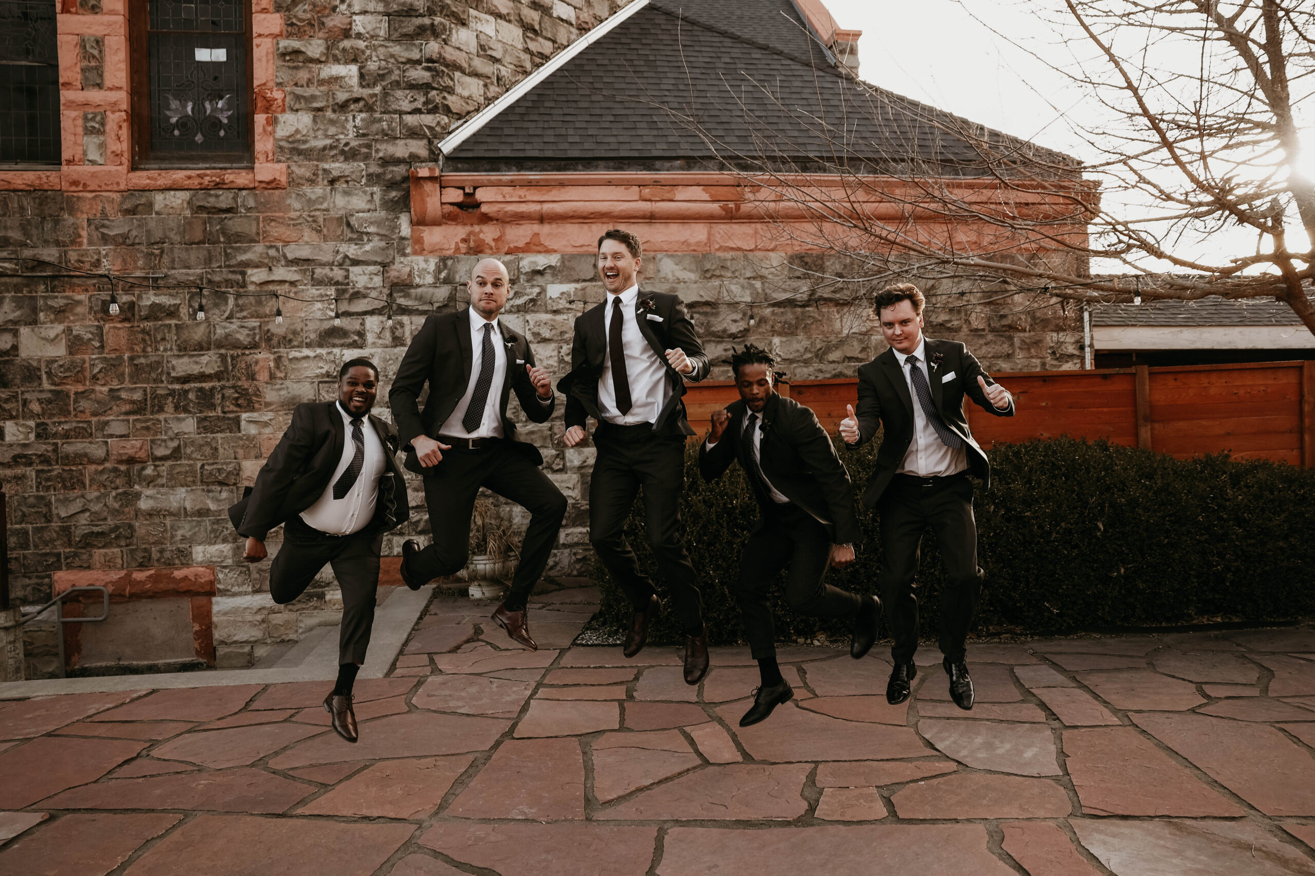 groom and groomsmen jumping up into the air 