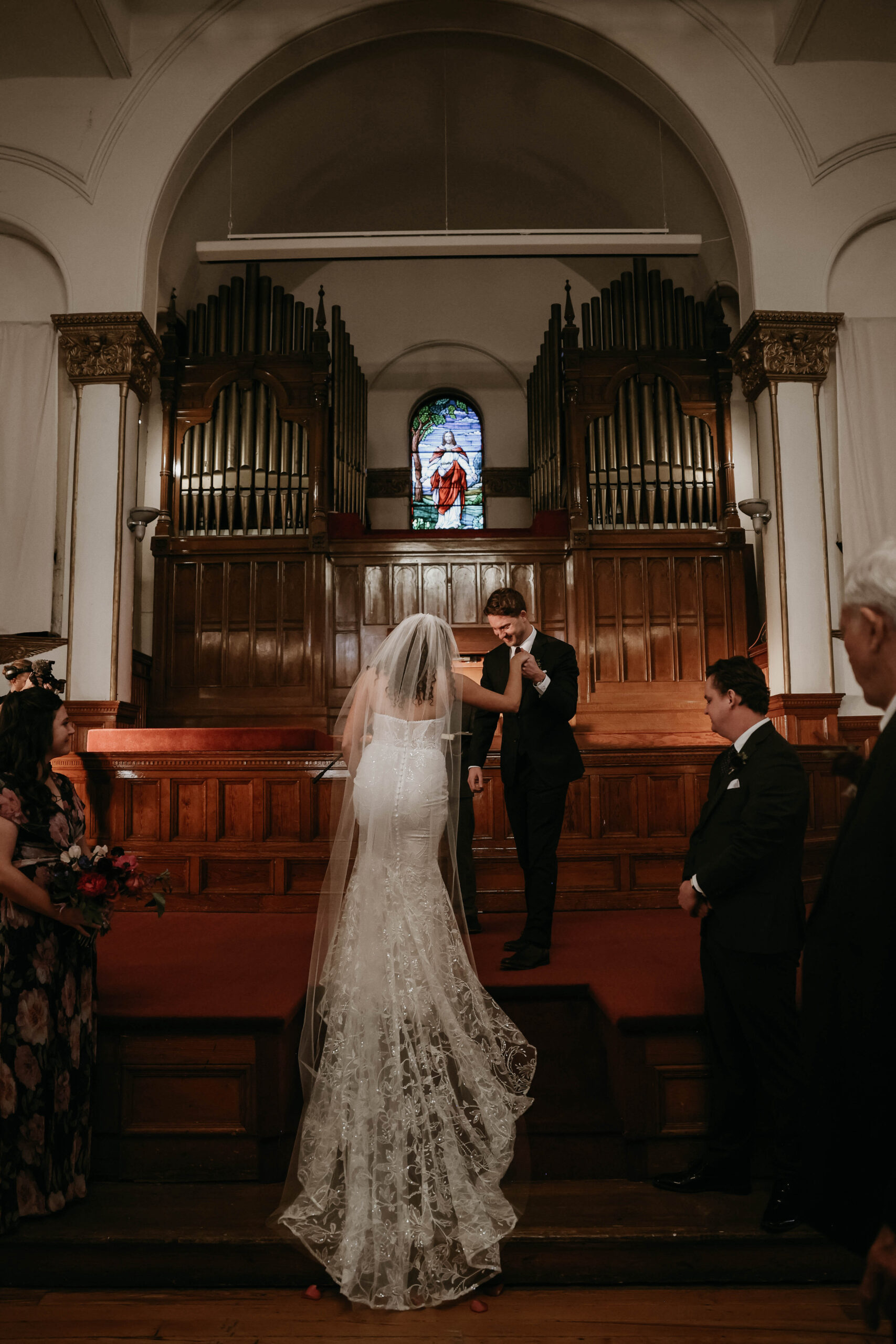 meaningful wedding moments of groom helping bride up onto the altar 