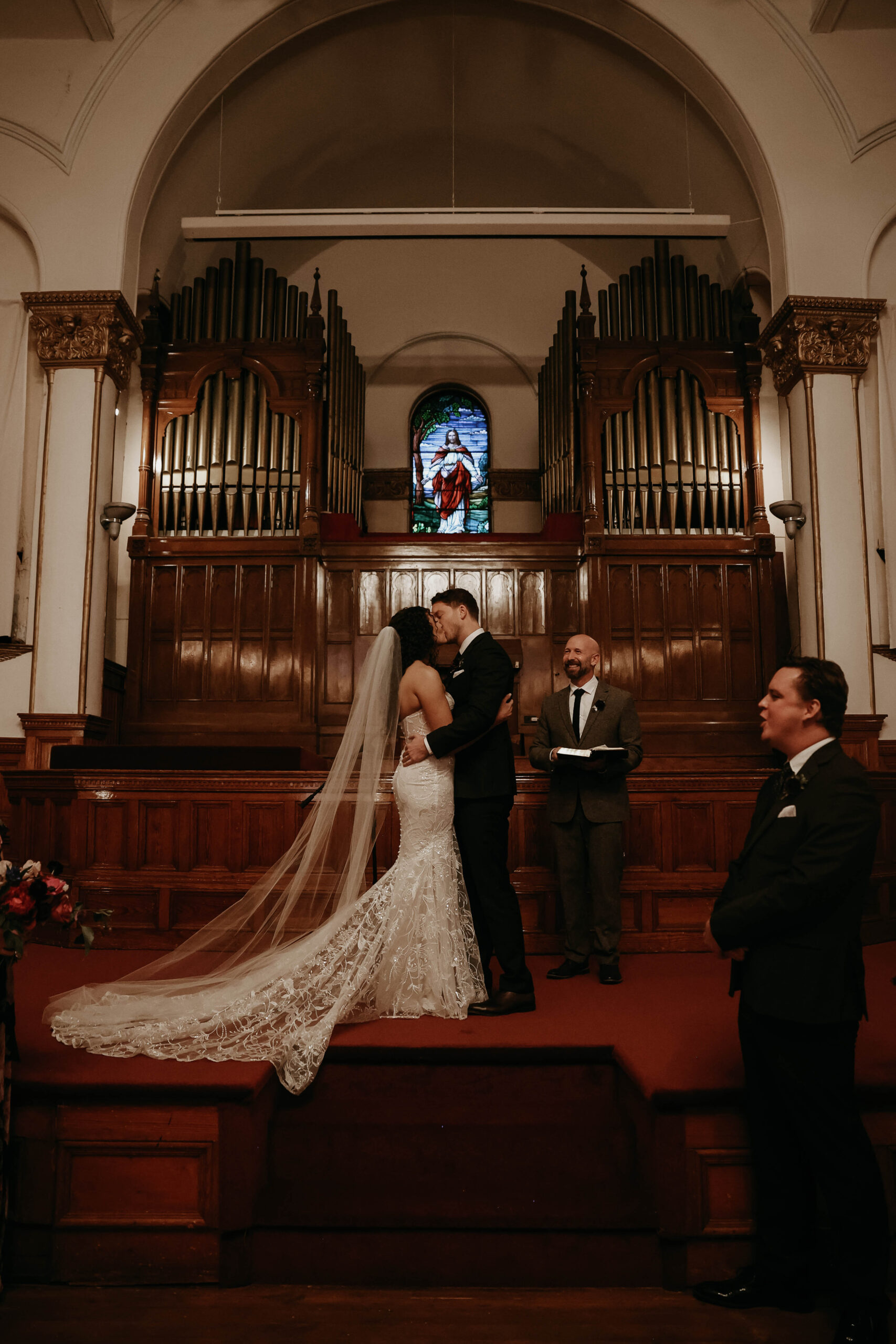 meaningful wedding moments of bride and groom kissing at the altar 
