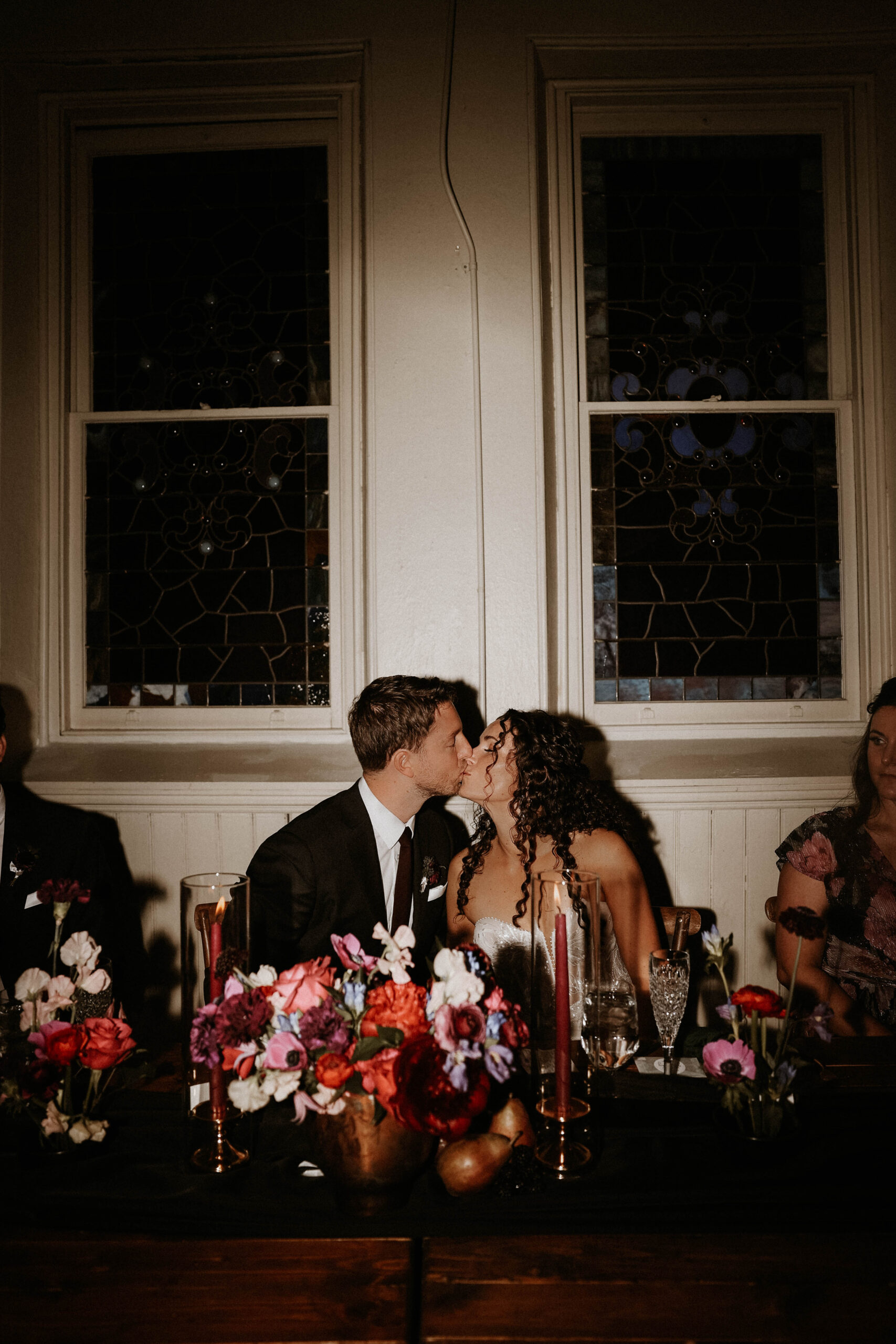 bride and groom kissing at the reception table 