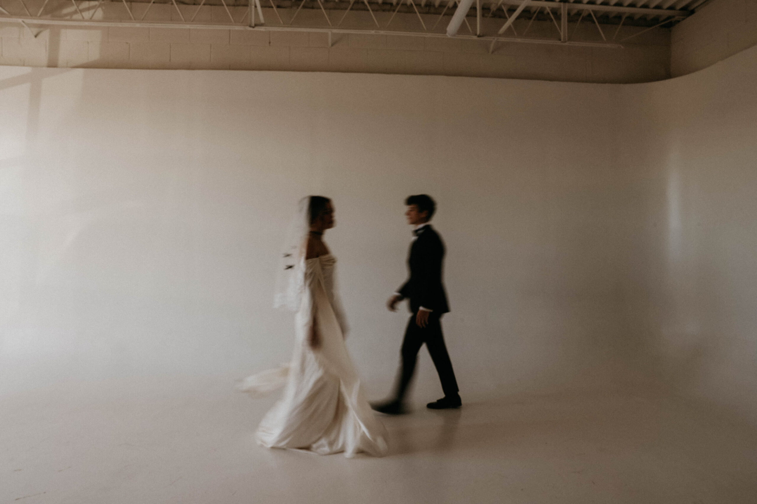 blurry image of bride and groom walking towards each other in studio