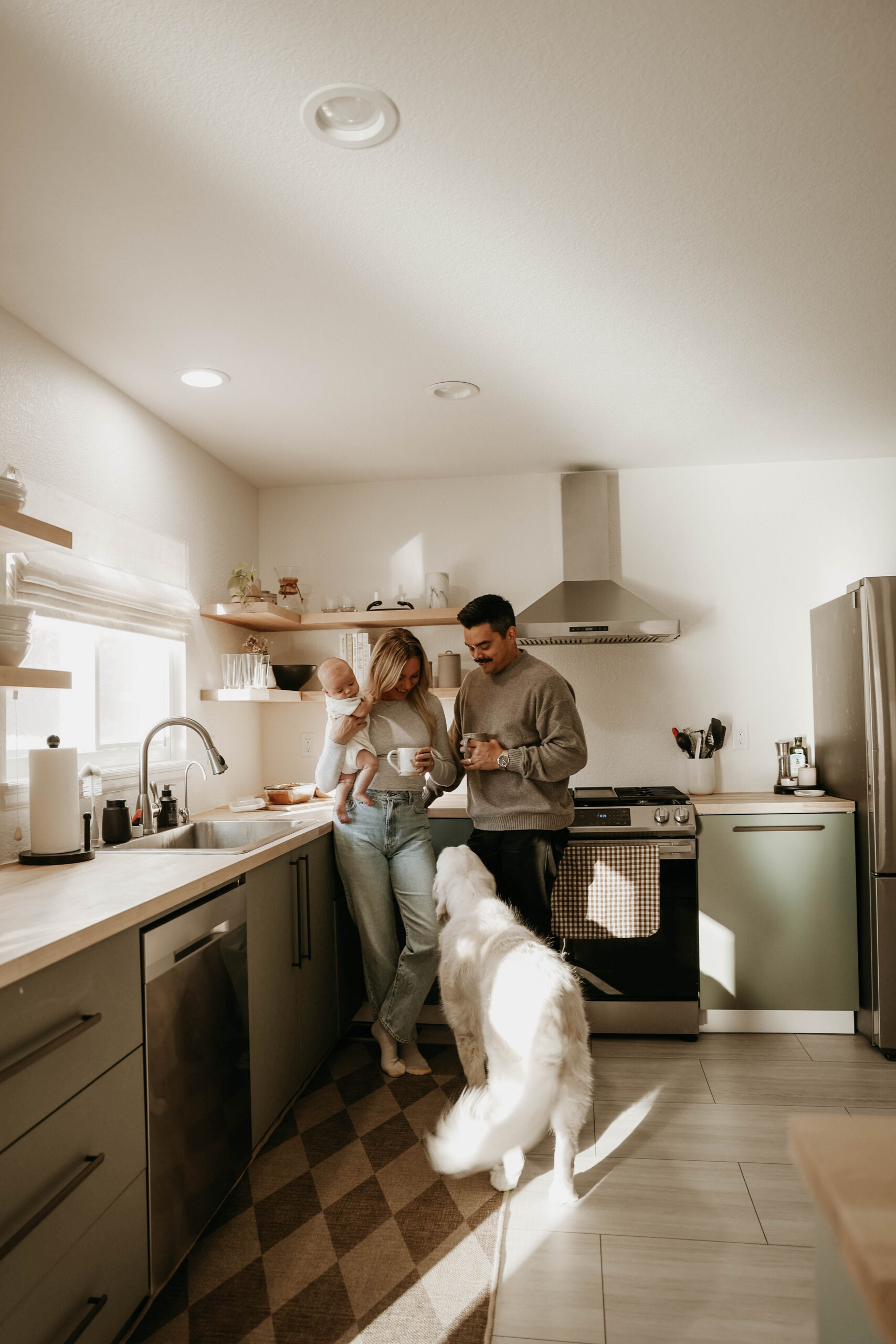 a family standing in their kitchen holding their baby with their dog during in-home family photos 