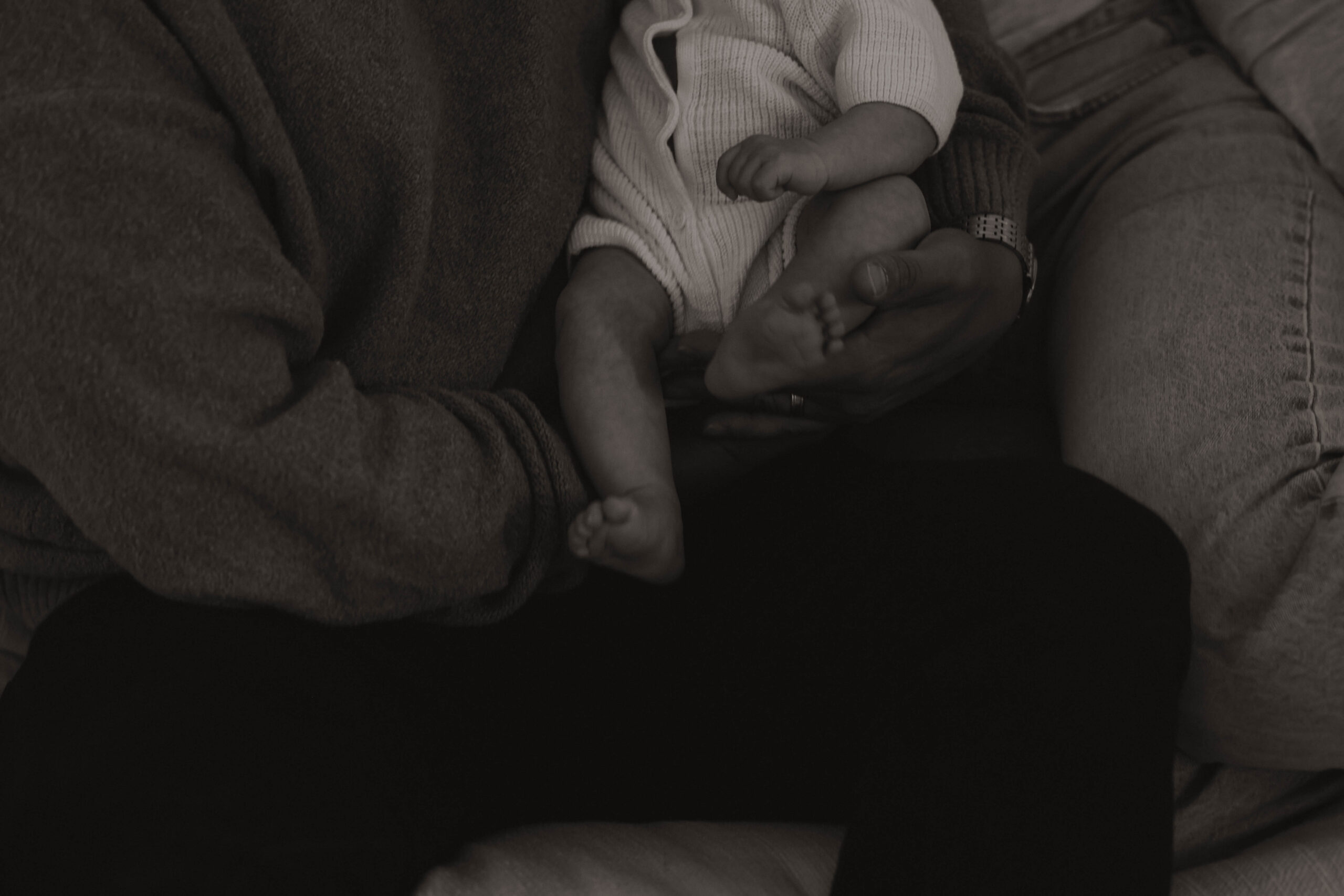 close up of dad holding new baby during in-home family photos 