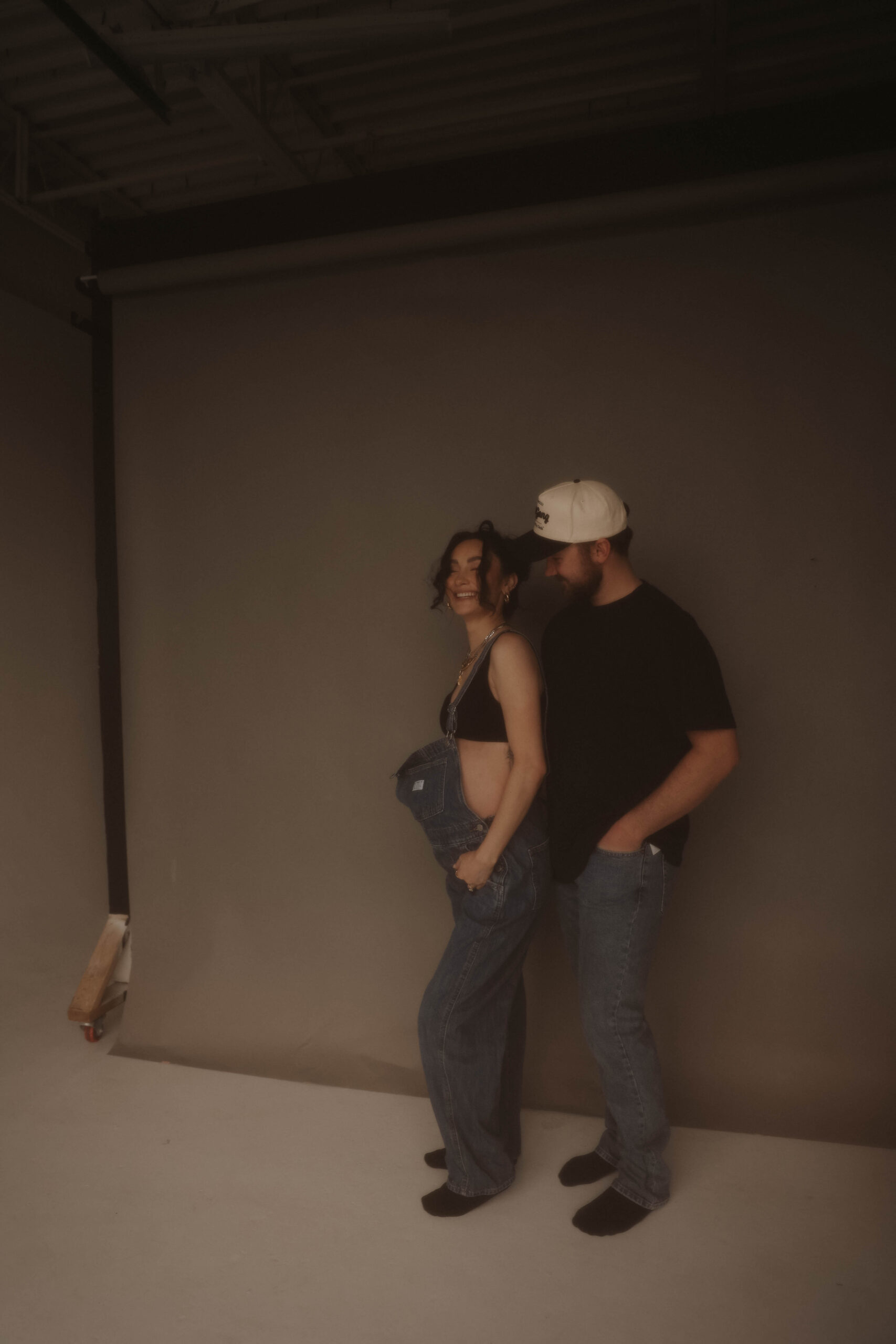 soon to be parents laughing together during denver maternity photoshoot