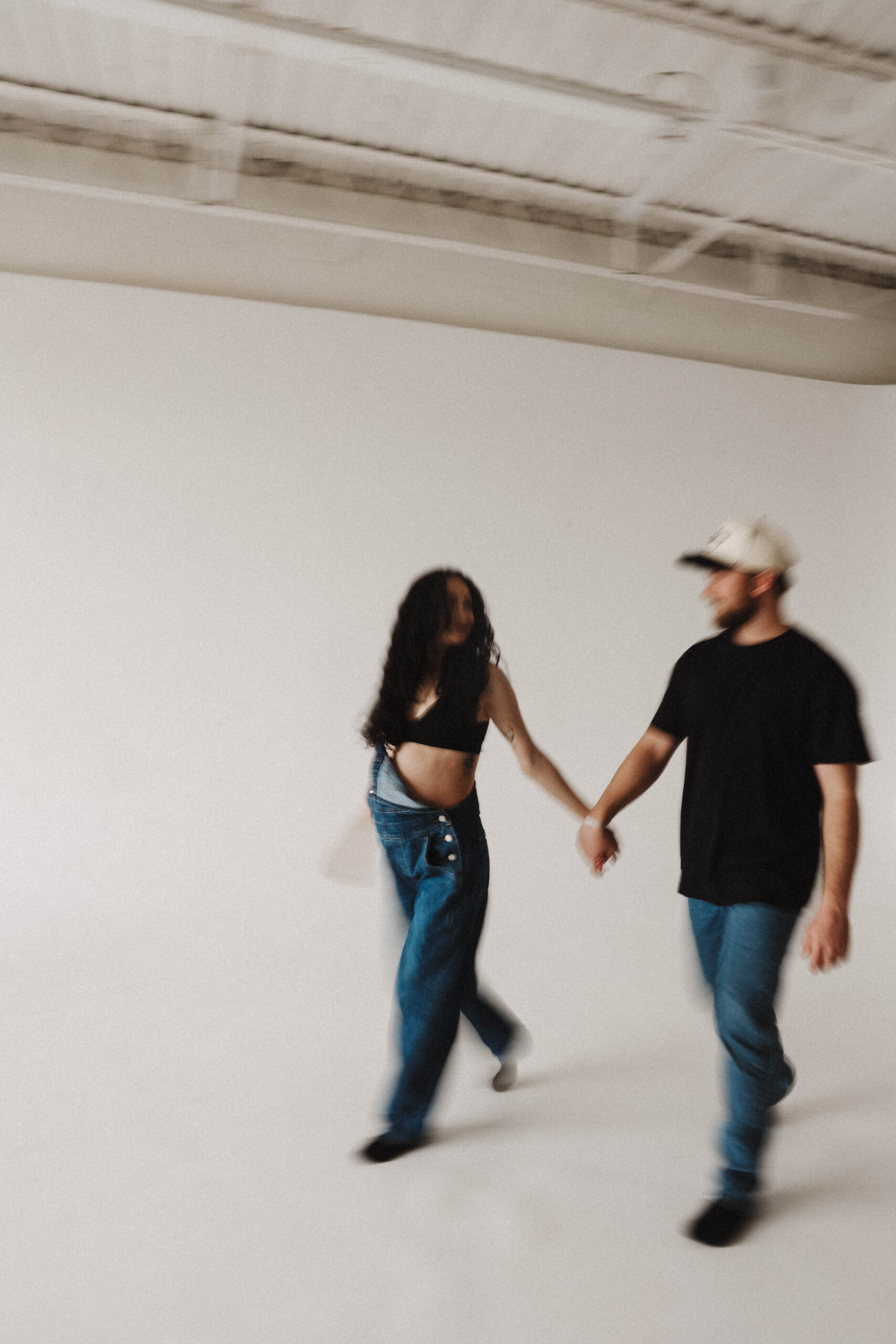blurry photo of soon to be parents holding hands during a denver maternity photoshoot