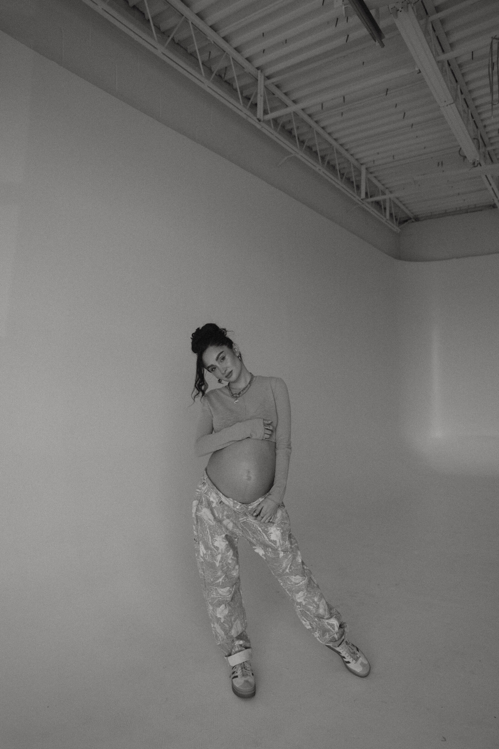 a pregnant woman posing in a studio during denver maternity photoshoot
