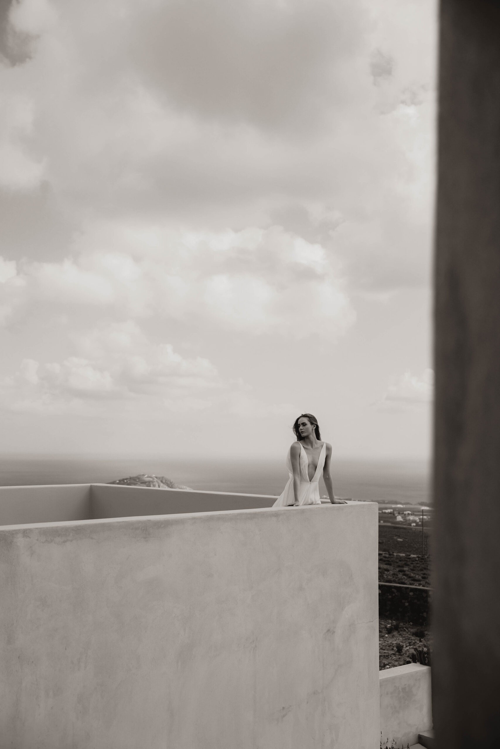 bride leaning against the railing of villa for Santorini Greece elopement
