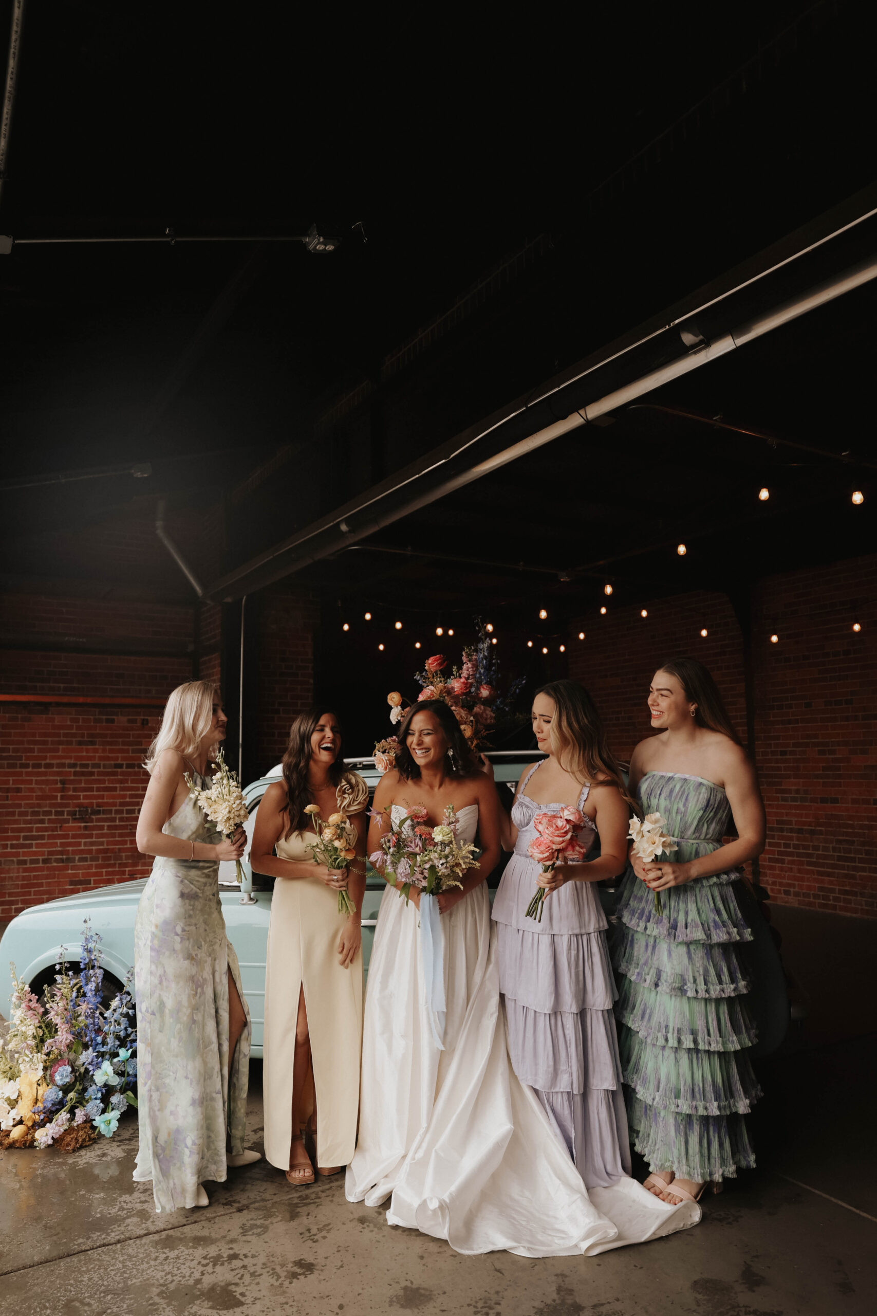 bride and bridesmaids photo in front of floral styled car during a colorful spring wedding 