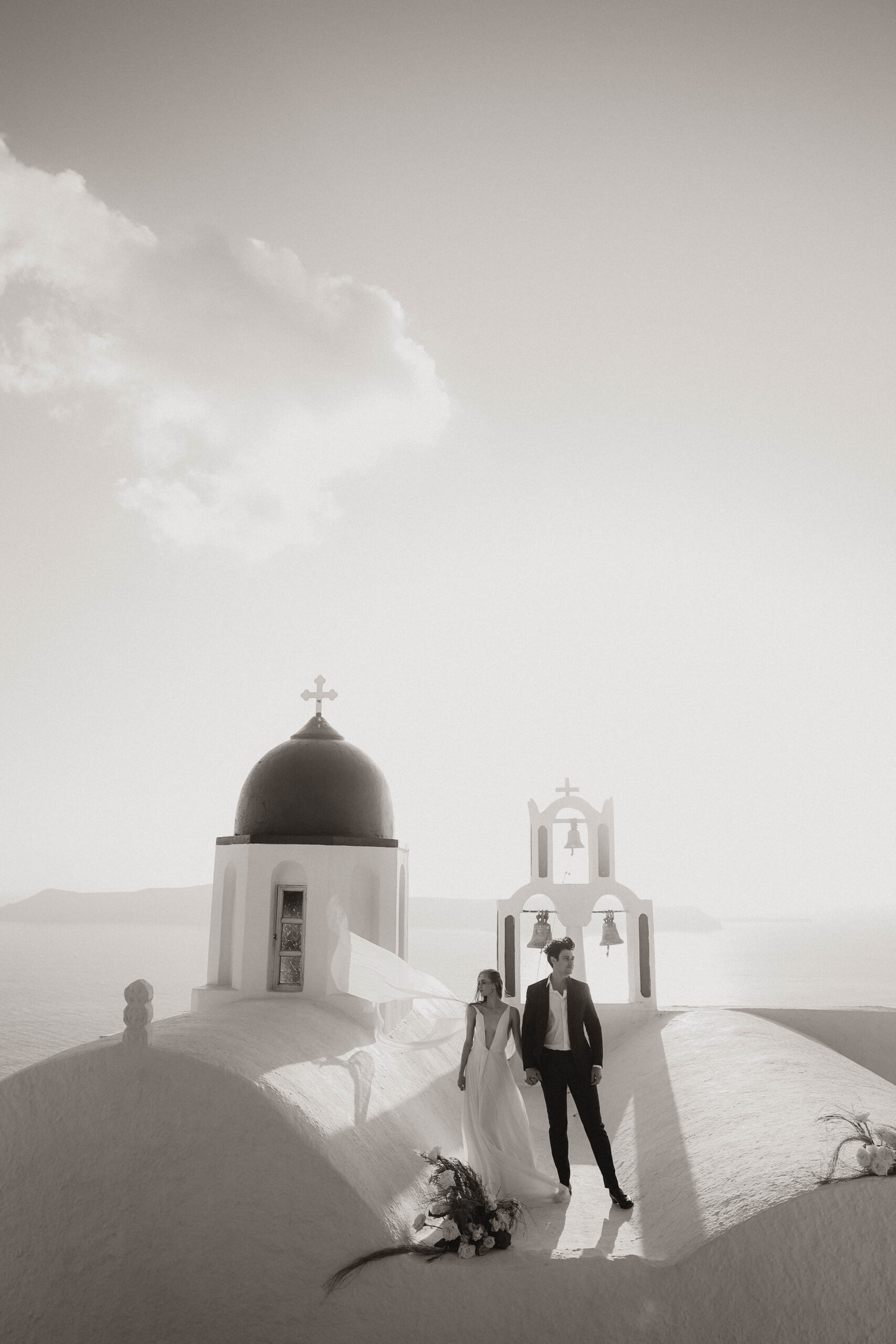 bride and groom posing on a roof for Santorini Greece elopement